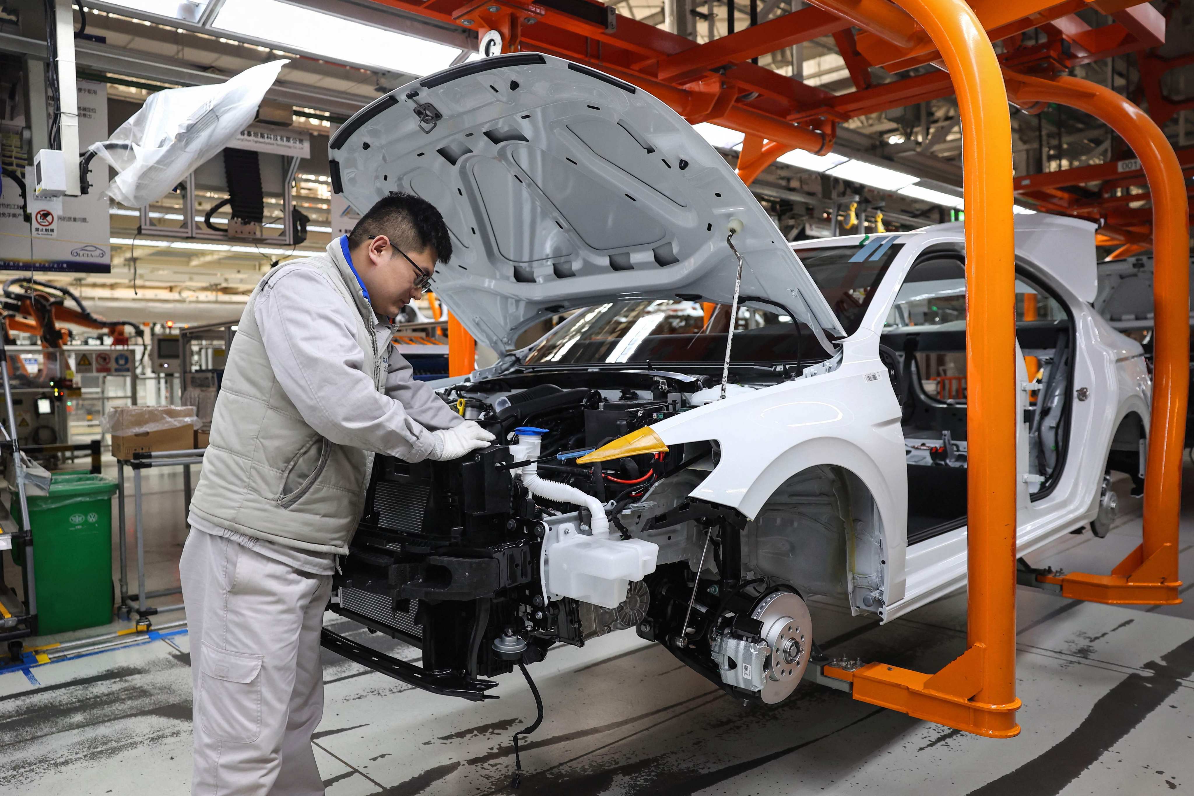 An employee works on a car assembly line at a factory of FAW-Volkswagen company in Qingdao, in eastern Shandong province, on March 12. Photo: AFP