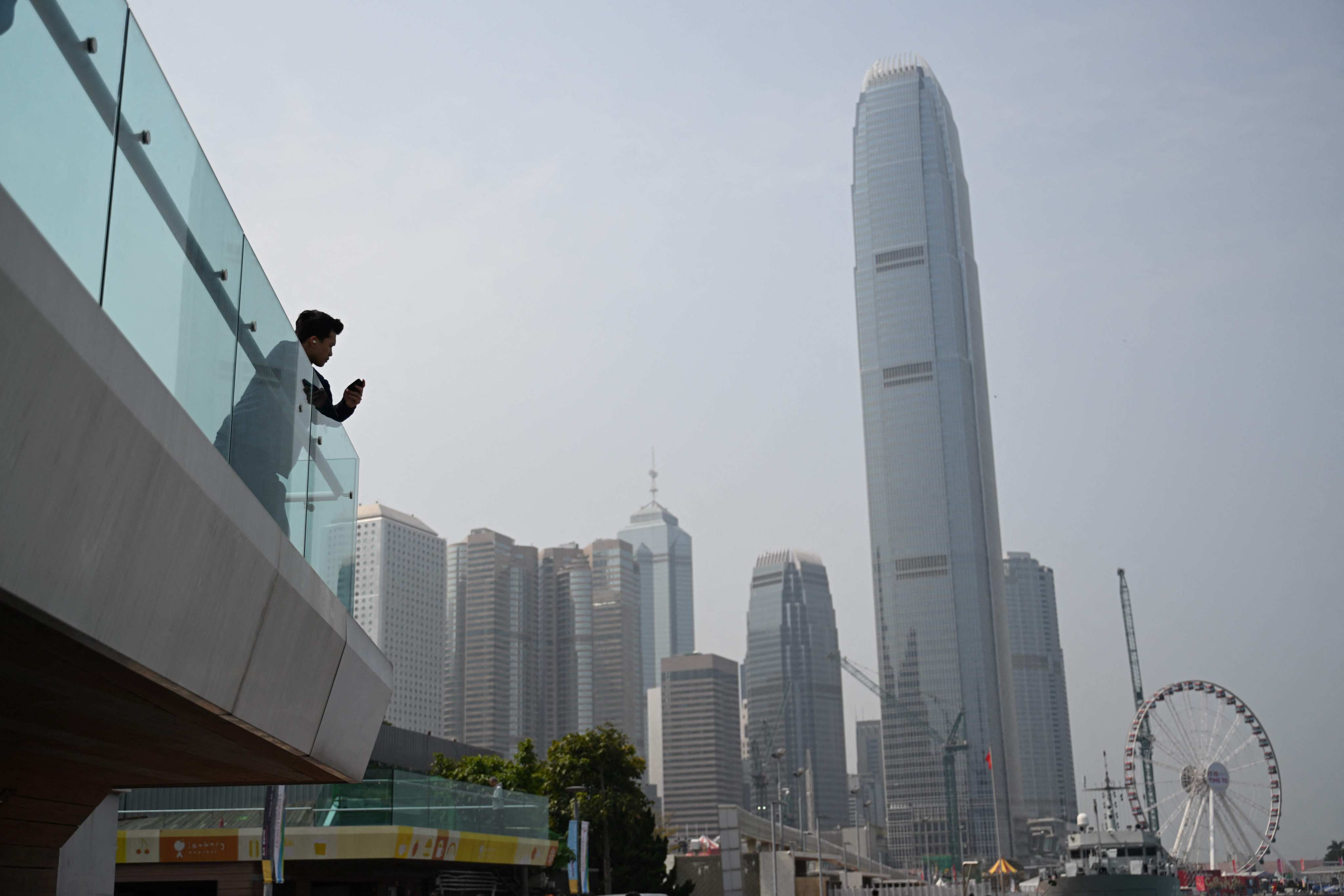 A visitor looks out over Hong Kong’s central business district on February 18. The city is facing its toughest fiscal test in three decades following a three-year run of substantial deficits. Photo: AFP