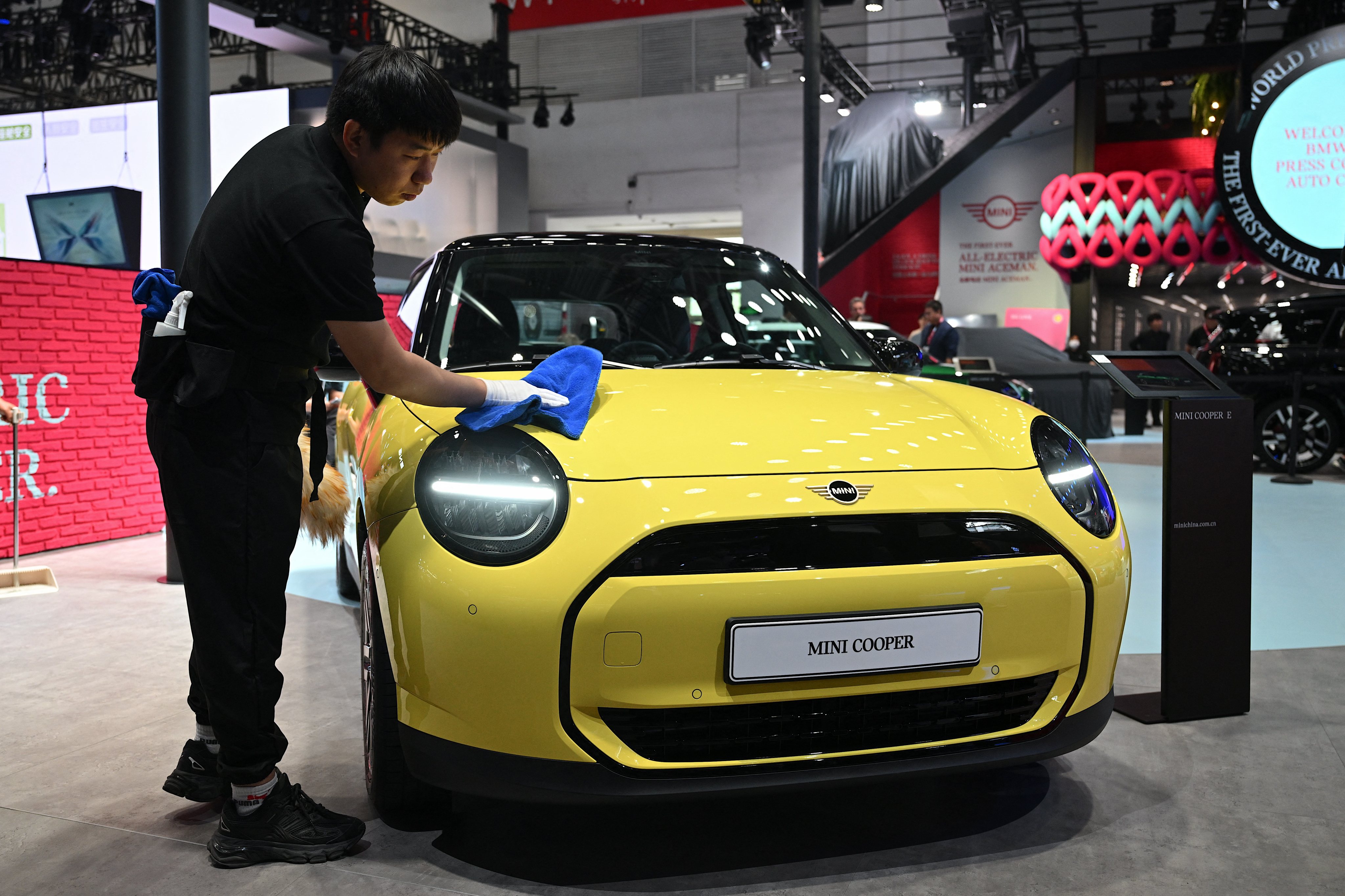 An electric Mini Cooper car is wiped down at the Beijing Auto Show in April. The Mini series, under the BMW umbrella, is subject to tariffs by the European Union on China-made vehicles exported there. Photo: AFP