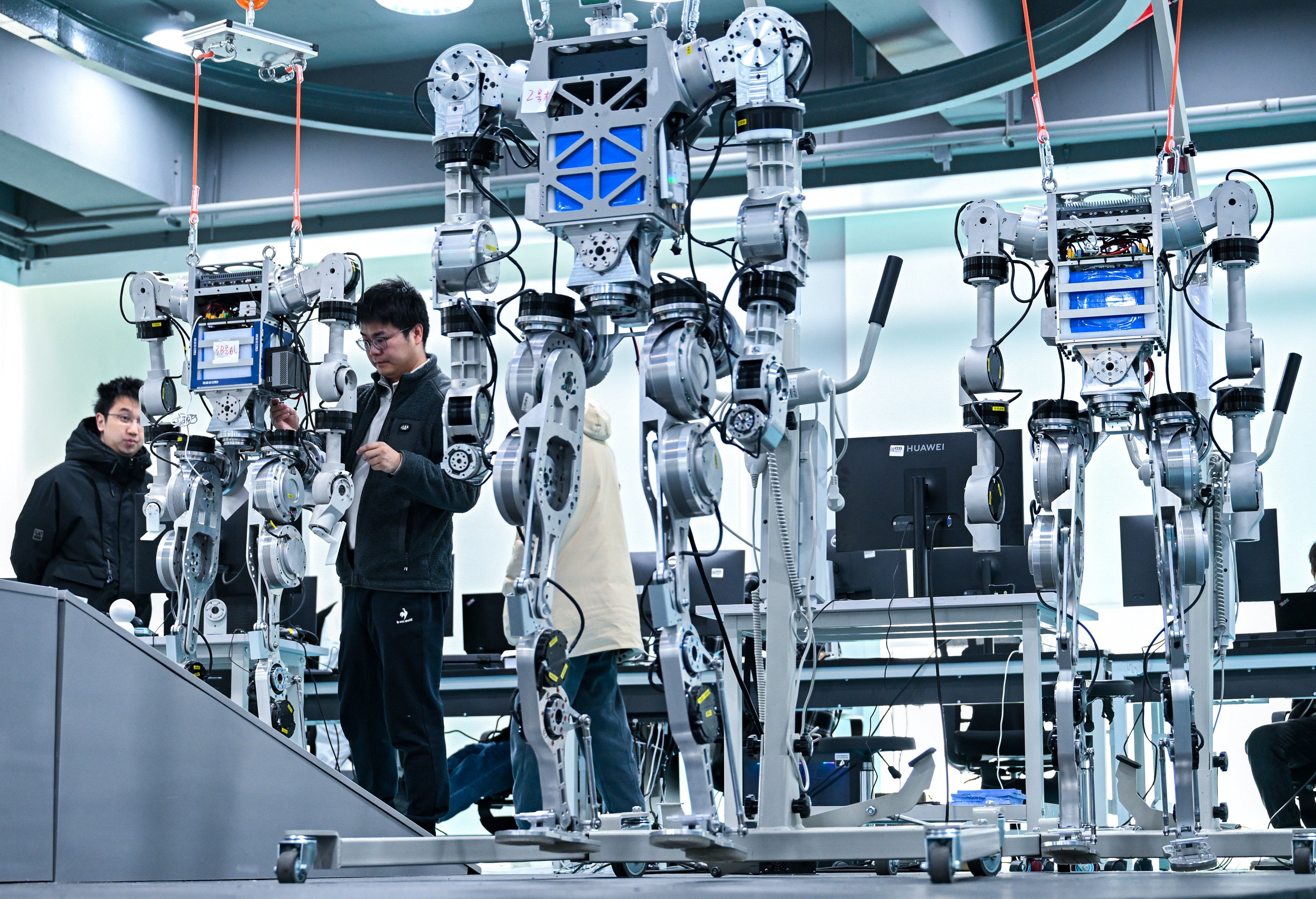 Engineers debug a humanoid robot at a technology company in China’s Hubei province last month. Beijing is hanging some hopes for GDP growth on technological advancements. Photo: Xinhua