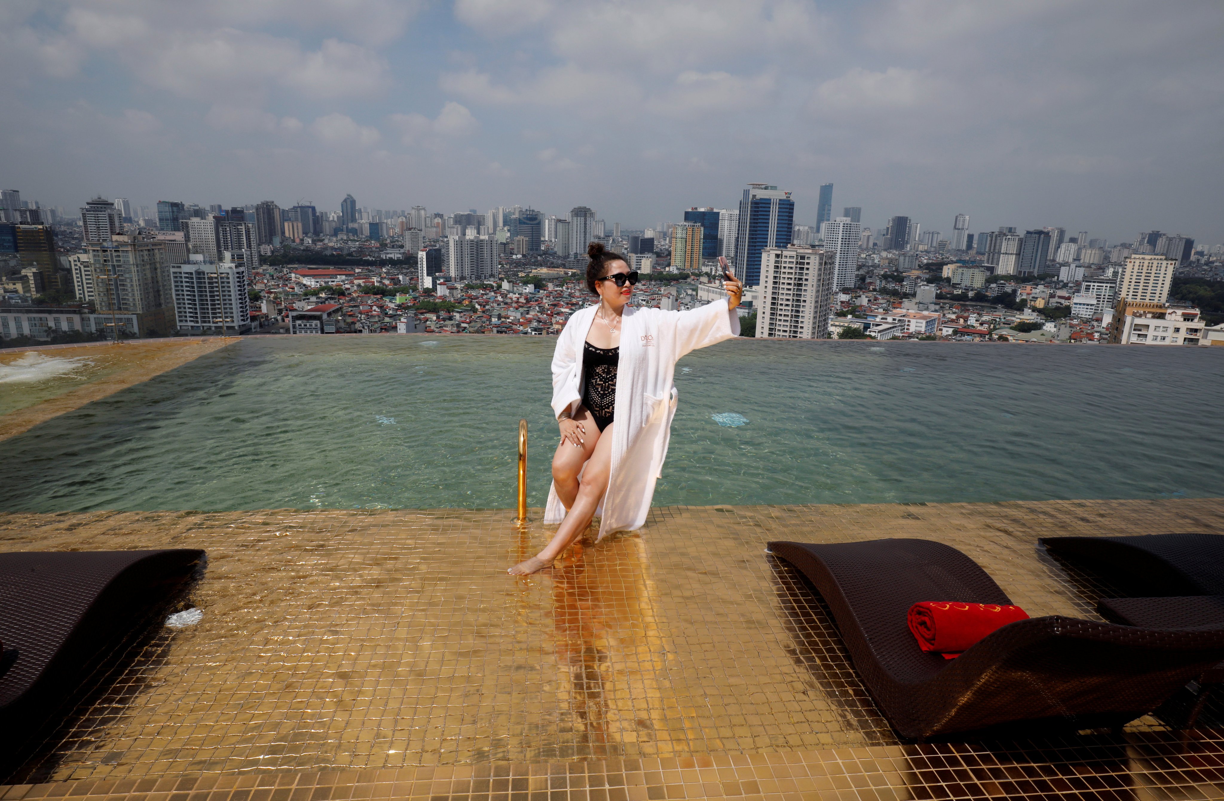 A woman poses for a photo at a gold plated infinity pool of a luxury hotel in Hanoi, Vietnam in 2020, after the government eases a nationwide Covid-19 lockdown. Photo: Reuters