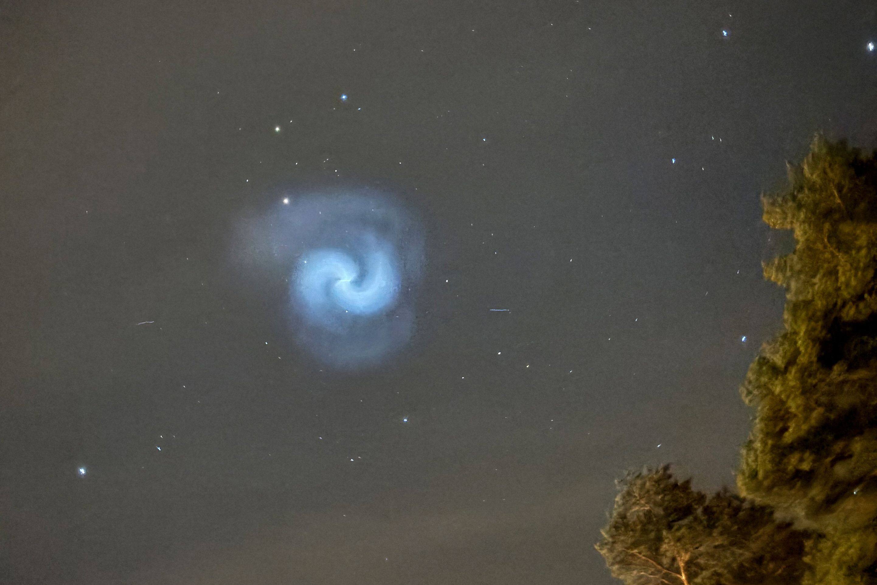 A picture taken in the countryside near Dalby-Viggeby, south of Uppsala, Sweden, on Monday shows a blue and white spiral in the night sky reportedly created by frozen fuel tumbling from a SpaceX rocket. Photo: Bertrand Ilhe via AFP