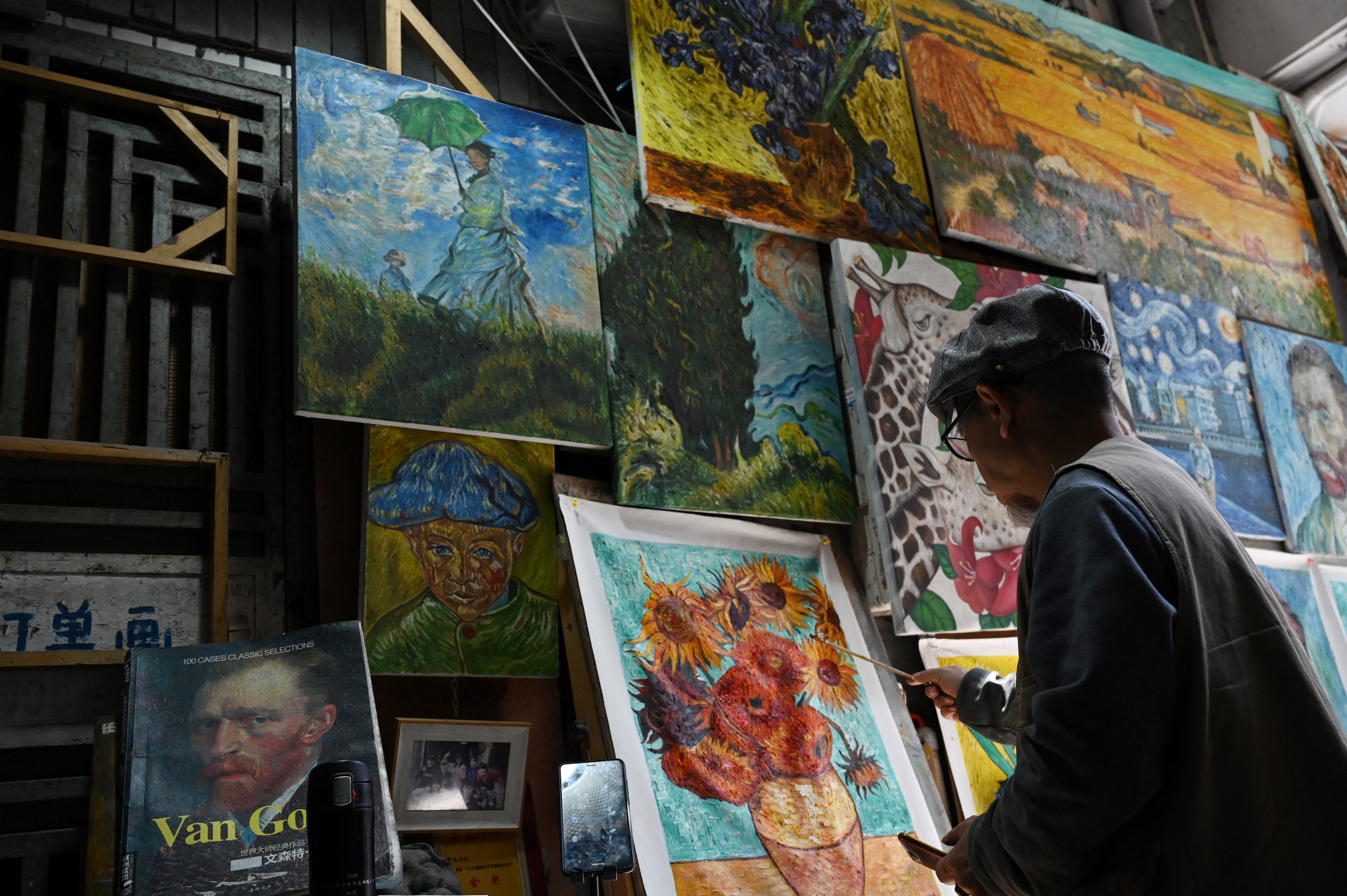An artist paints a replica of Vincent van Gogh’s Sunflowers in a Dafen village alley. Many painters in Dafen, once known for churning out fakes, now sell original works. Photo: AFP
