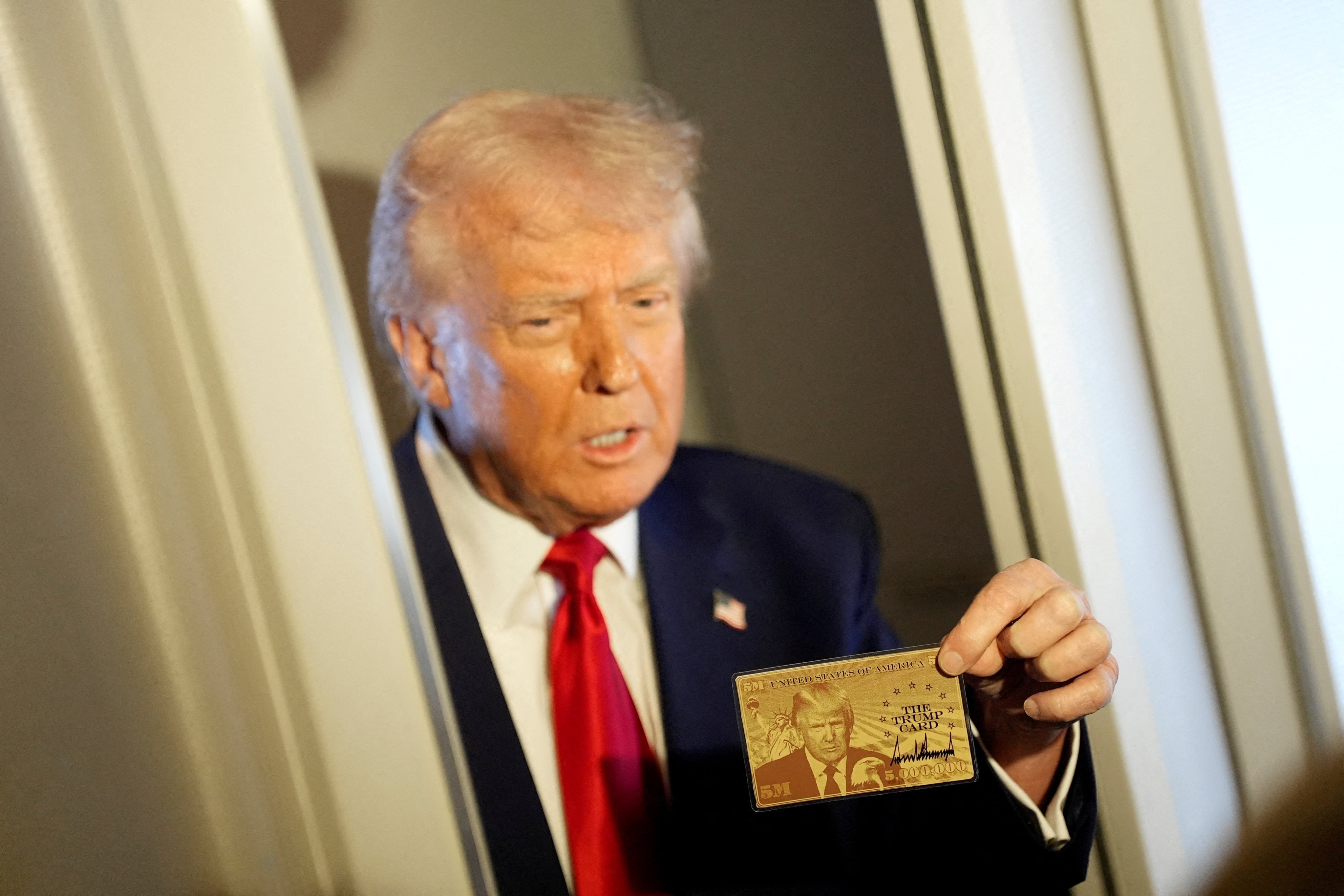 US President Donald Trump holding ‘The Trump Card’. Photo: Reuters