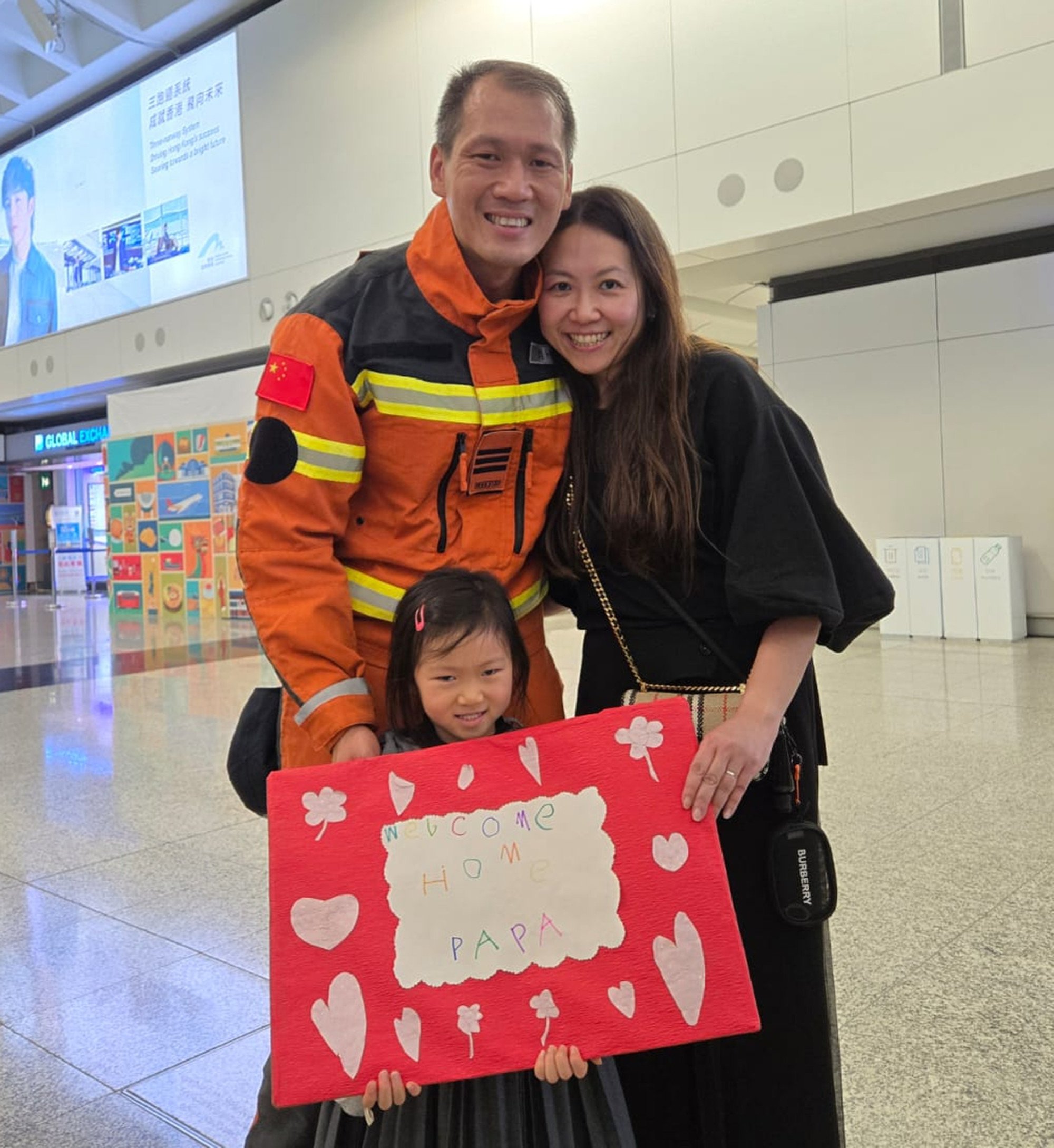 Gabriella Yip, four, holds up a sign to welcome back her father, senior firefighter Kit Yip. Photo: Jess Ma Gabriella Yip, four, holds up a sign to welcome back her father, senior firefighter Kit Yip. Photo: Jess Ma