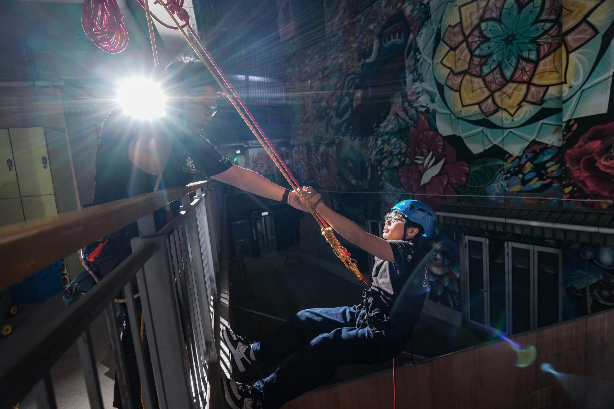 School dropout Chris (right) gets a hand from social worker Vulcan Chu while having a go at abseiling at the Youth Outreach Jockey Club Building. Photo: Eugene Lee School dropout Chris (right) gets a hand from social worker Vulcan Chu while having a go at abseiling at the Youth Outreach Jockey Club Building. Photo: Eugene Lee