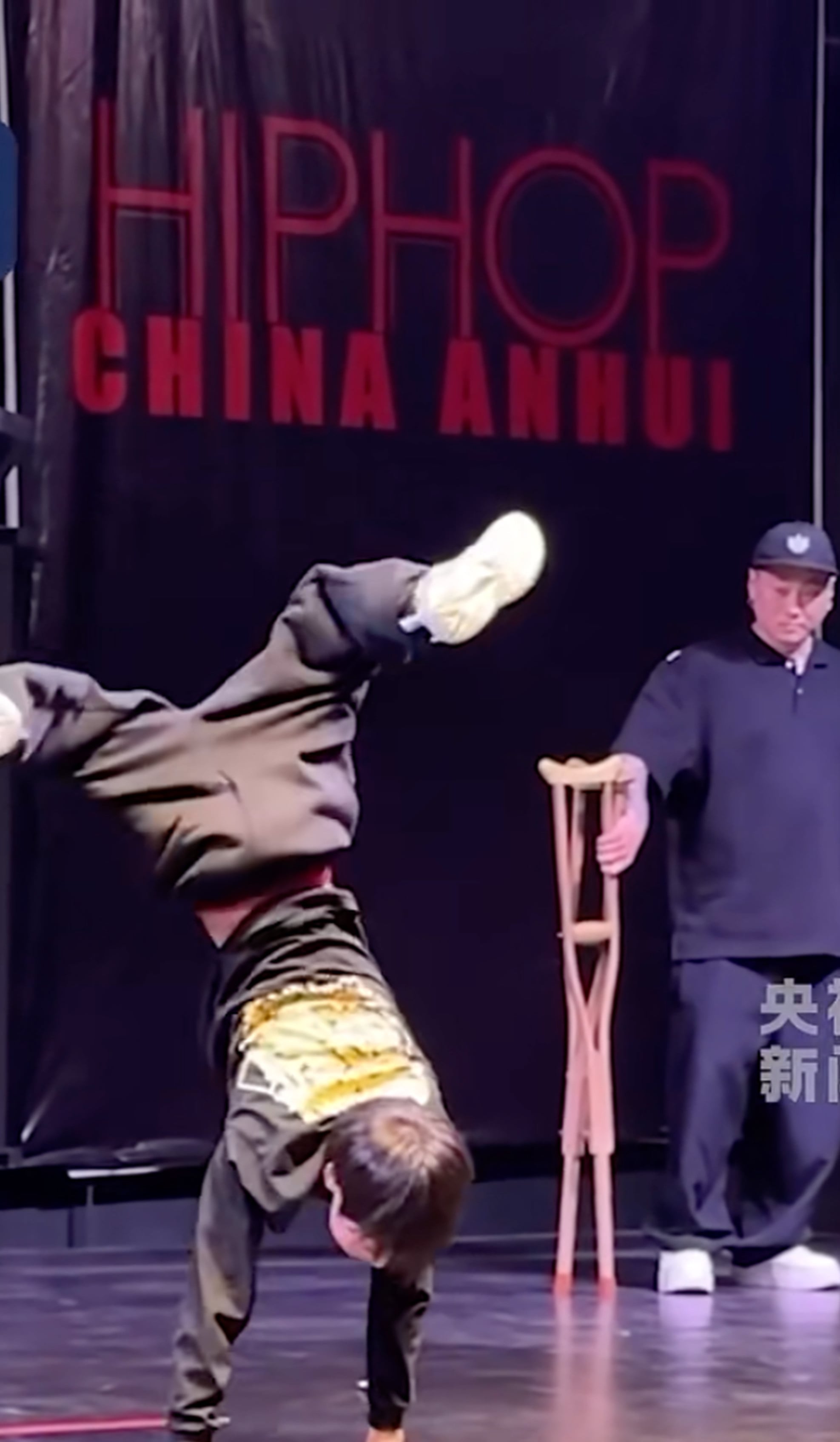 11-year-old Li executes some moves as his breakdancing coach looks on. Photo: CCTV