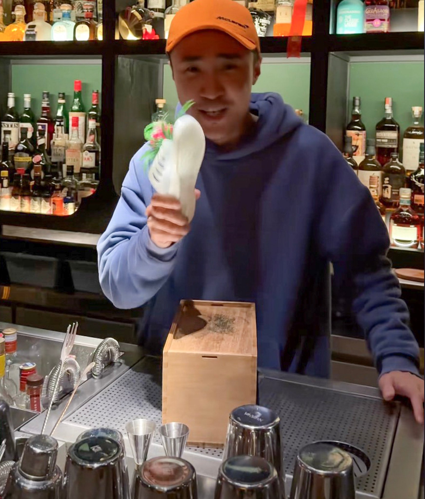 A member of staff at a bar holds a slipper which is used to “beat” away bad luck. Photo: Douyin A member of staff at a bar holds a slipper which is used to “beat” away bad luck. Photo: Douyin
