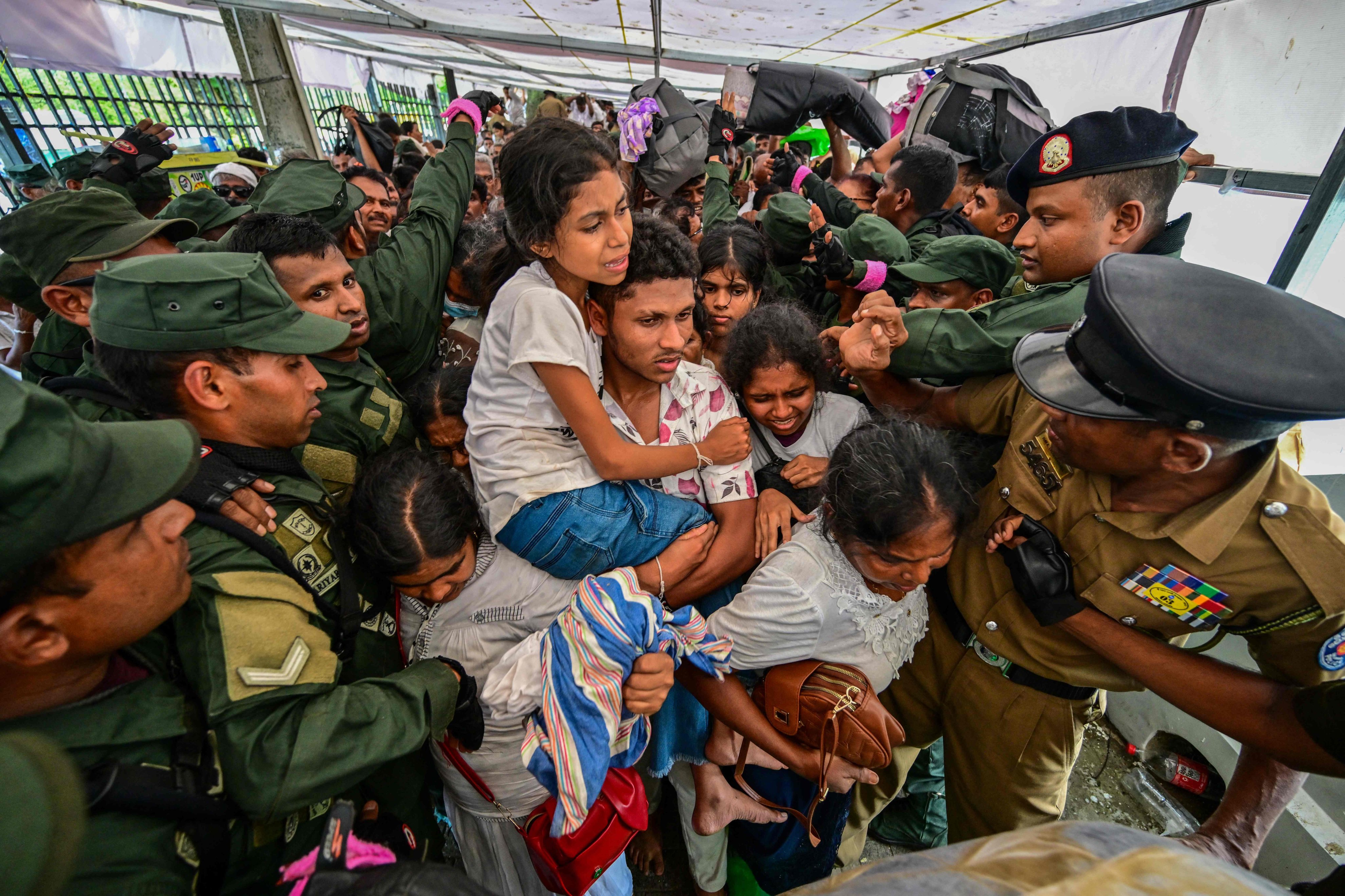 Security officials help devotees avoid chaos during a gathering for a public exposition of the sacred Tooth relic of the Buddha at the Temple of the Tooth in Kandy on Friday. Photo: AFP