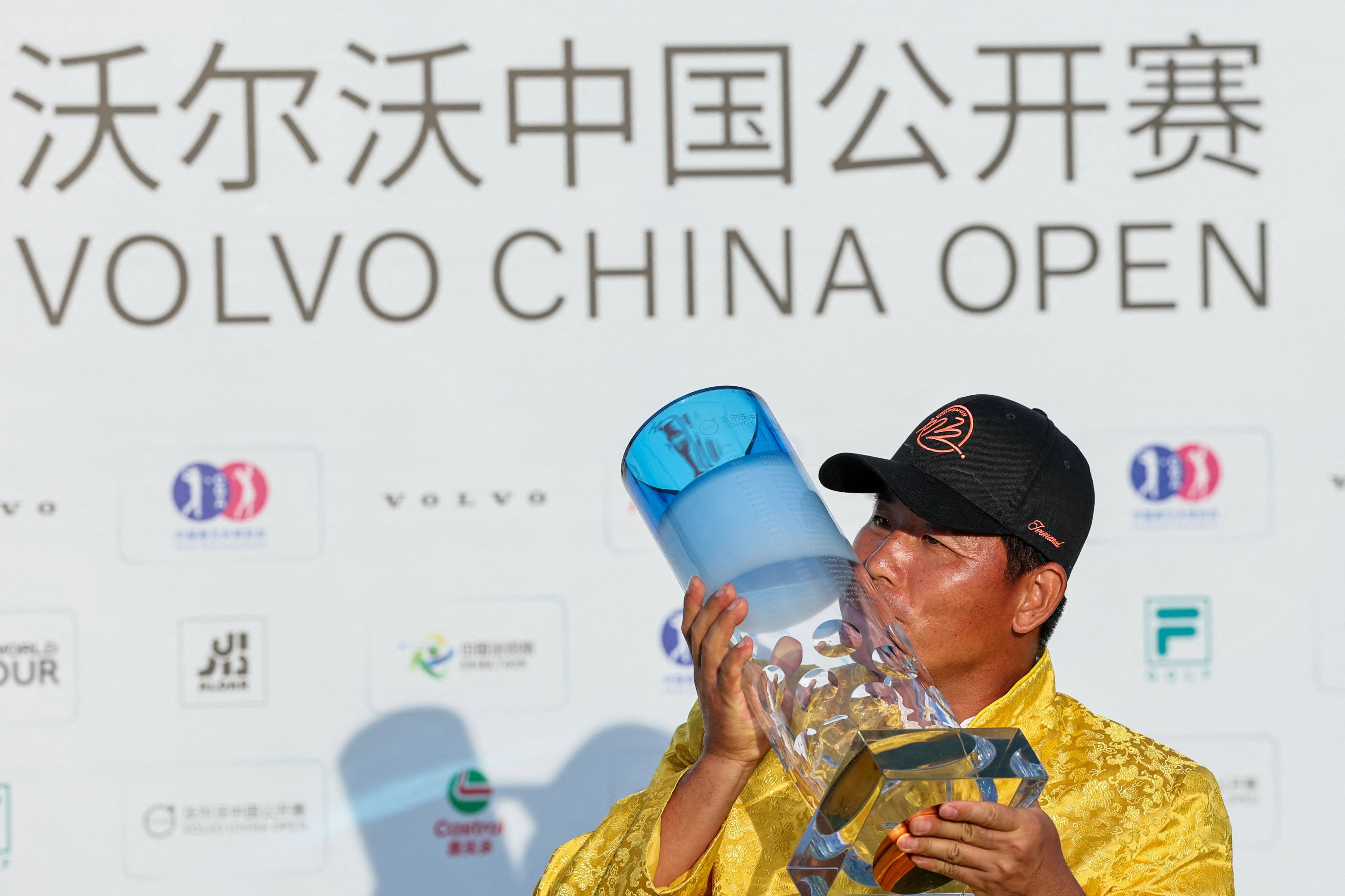 China’s Wu Ashun celebrates with the trophy after winning the China Open golf tournament in Shanghai. Photo: AFP