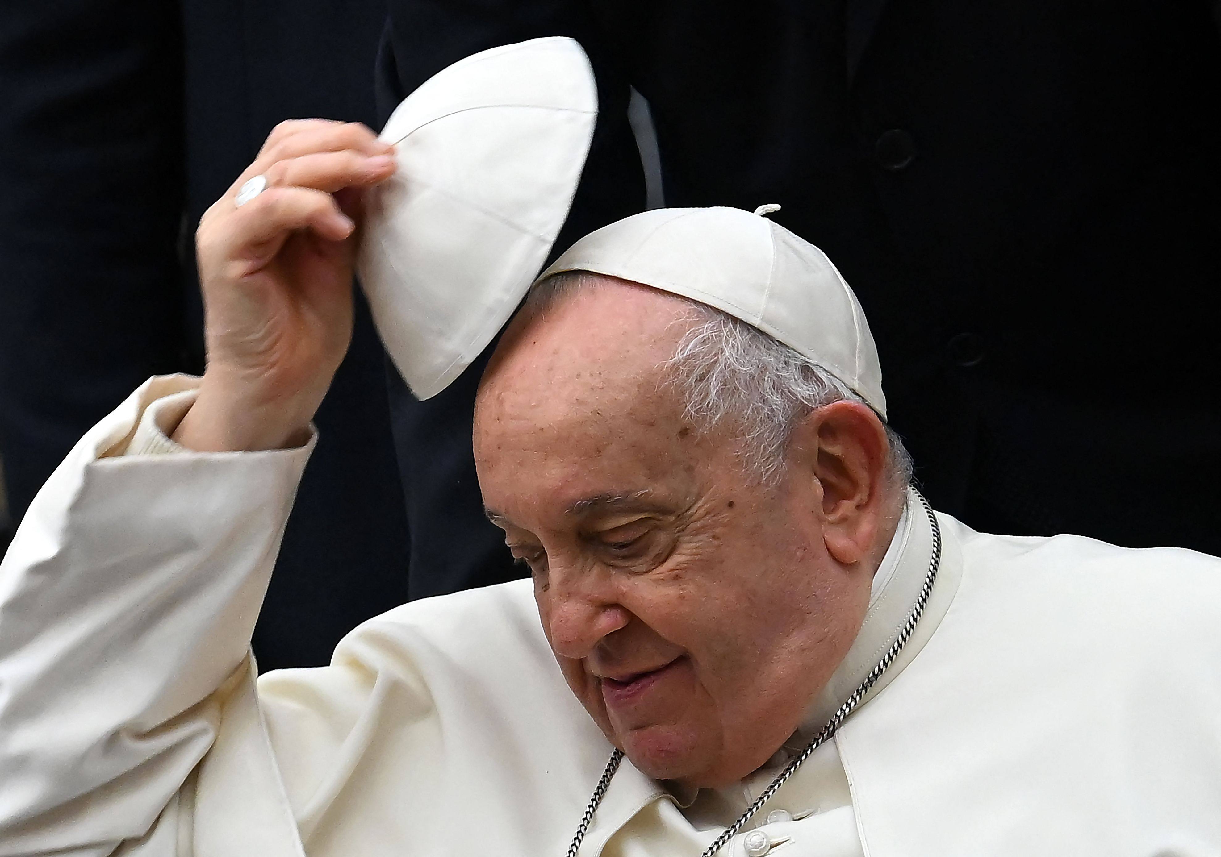 Pope Francis swaps his skull cap during the weekly general audience at the Vatican in January 2024. The death of the pontiff triggers several rituals, including mourning, a funeral, and a conclave. Photo: AFP