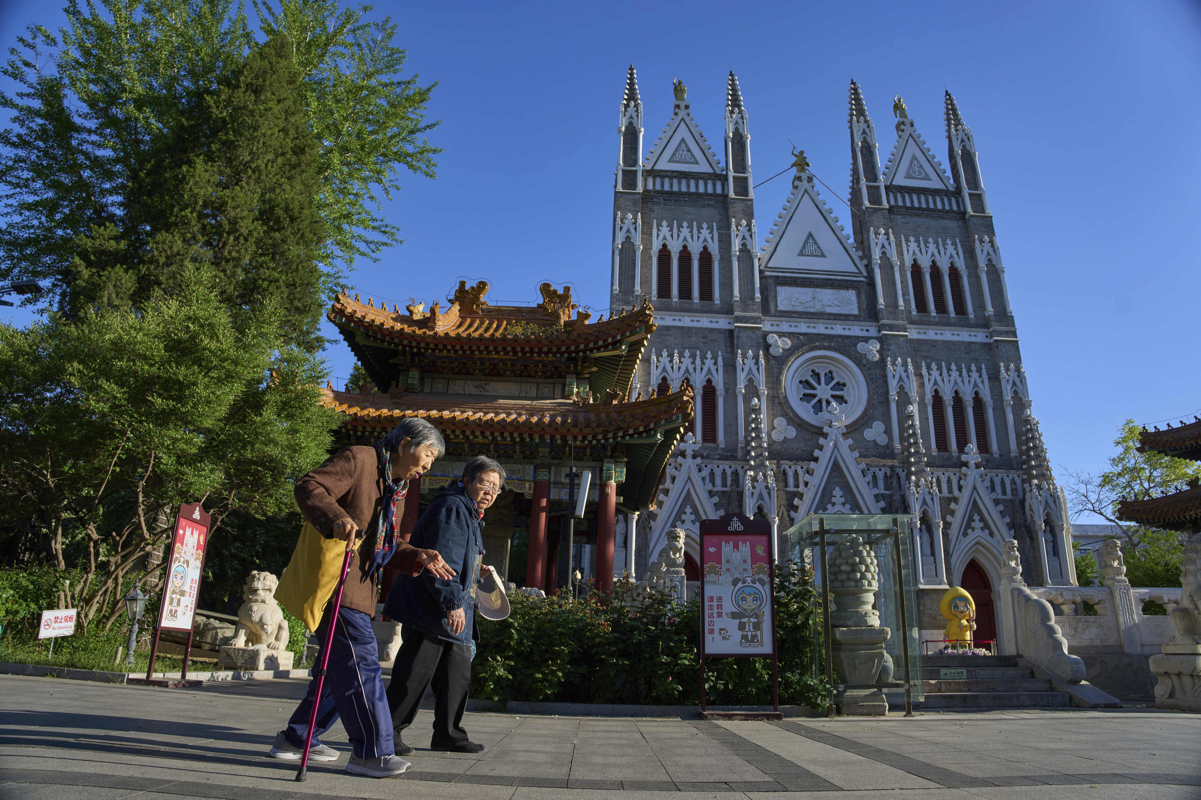 Women walk near the Xishiku Catholic Church in Beijing. Photo: AP