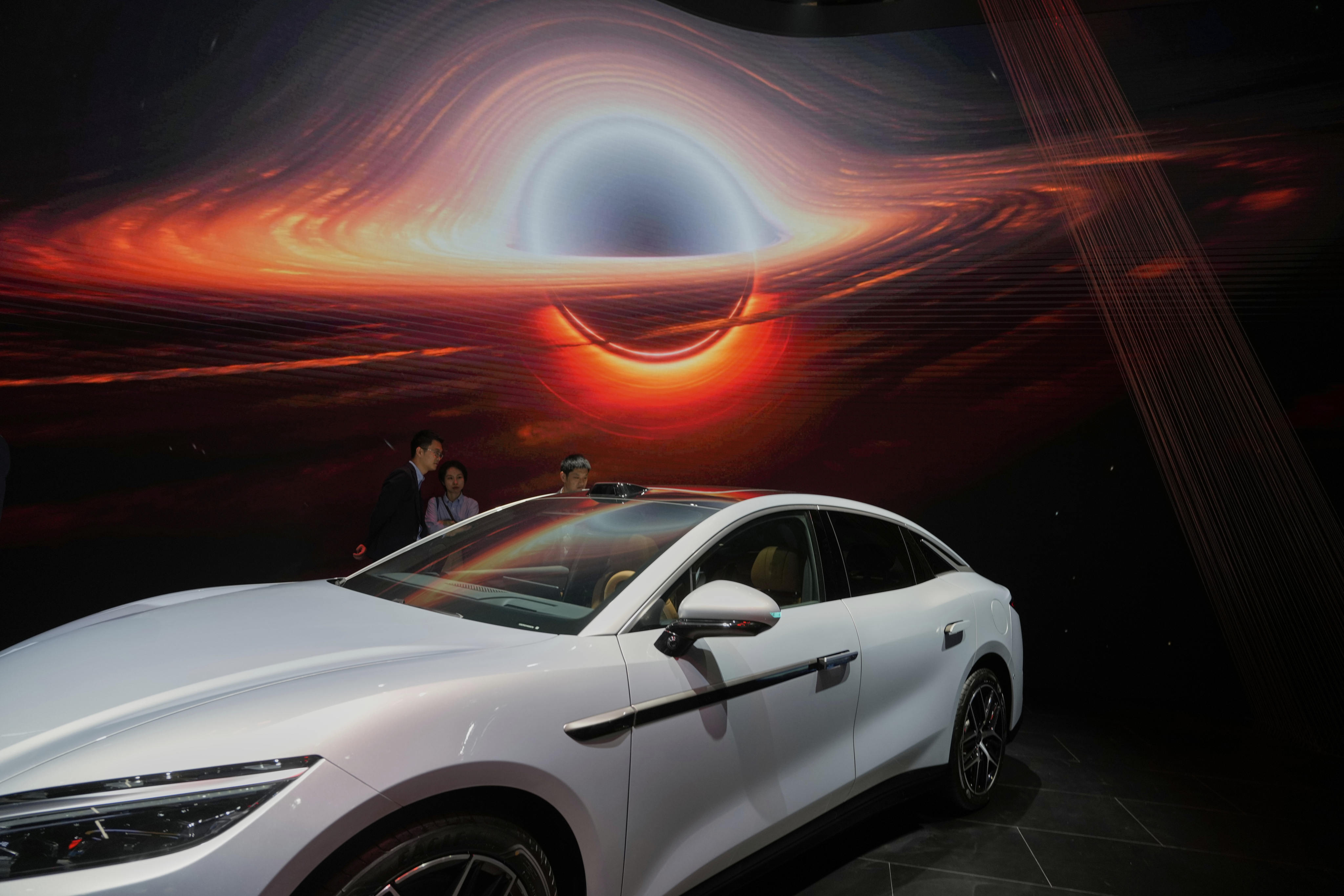 Shanghai auto show visitors look at a BYD electric car. Photo: AP