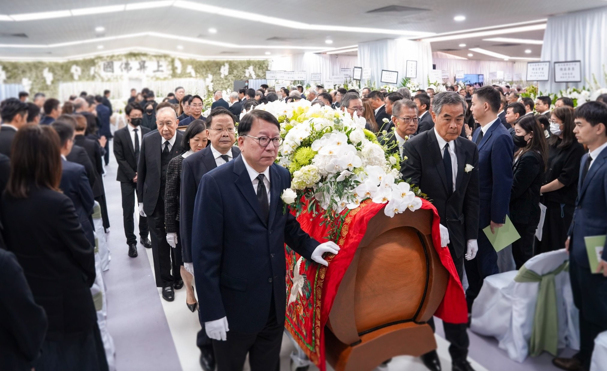 Chief Secretary Eric Chan (front left) and former leader Leung Chun-ying (front right) were among political and business heavyweights who walked with the late tycoon’s coffin. Photo: Handout