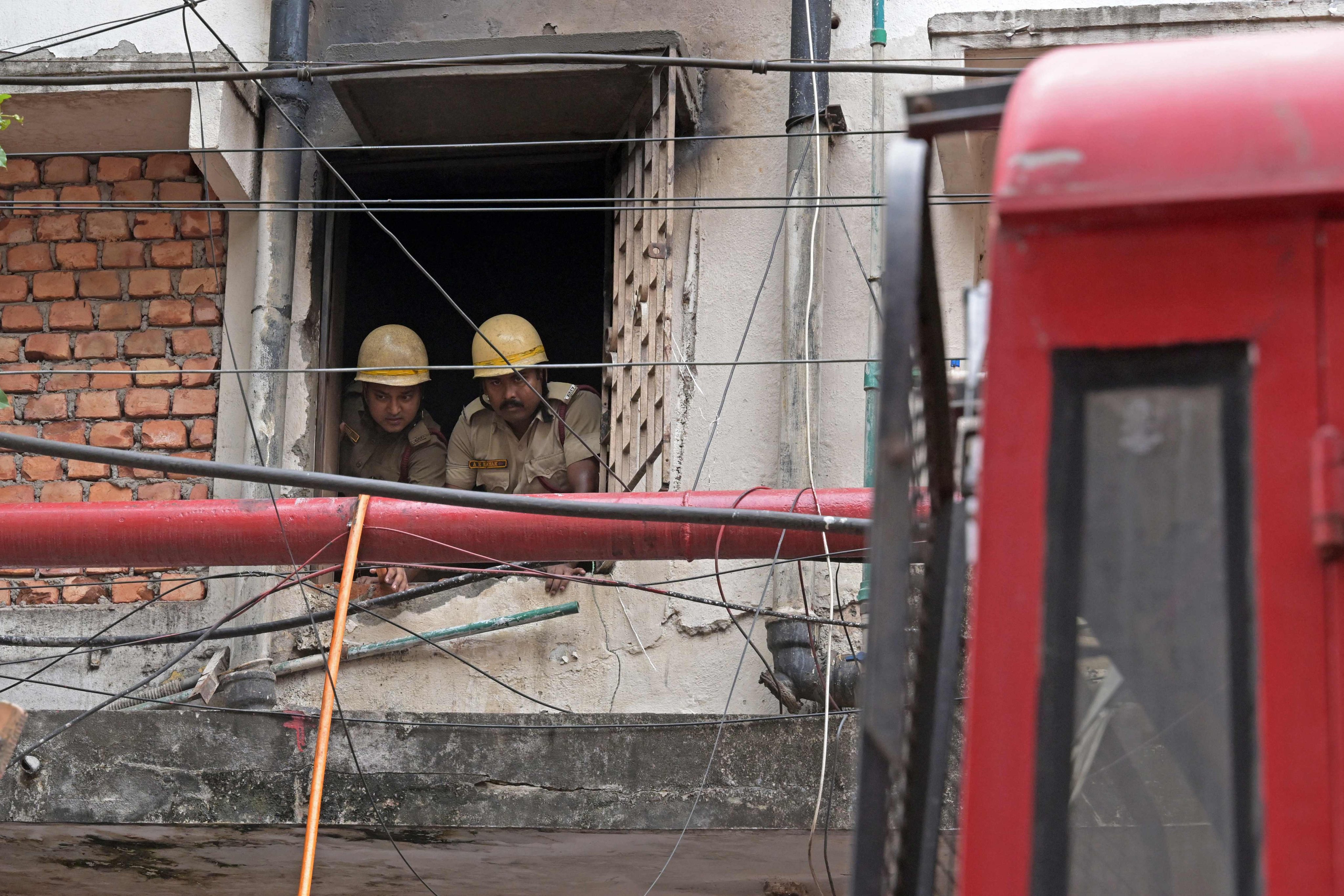 Firefighters inspect the Rituraj Hotel in Kolkata on Wednesday after a fire broke out overnight. Photo: AFP