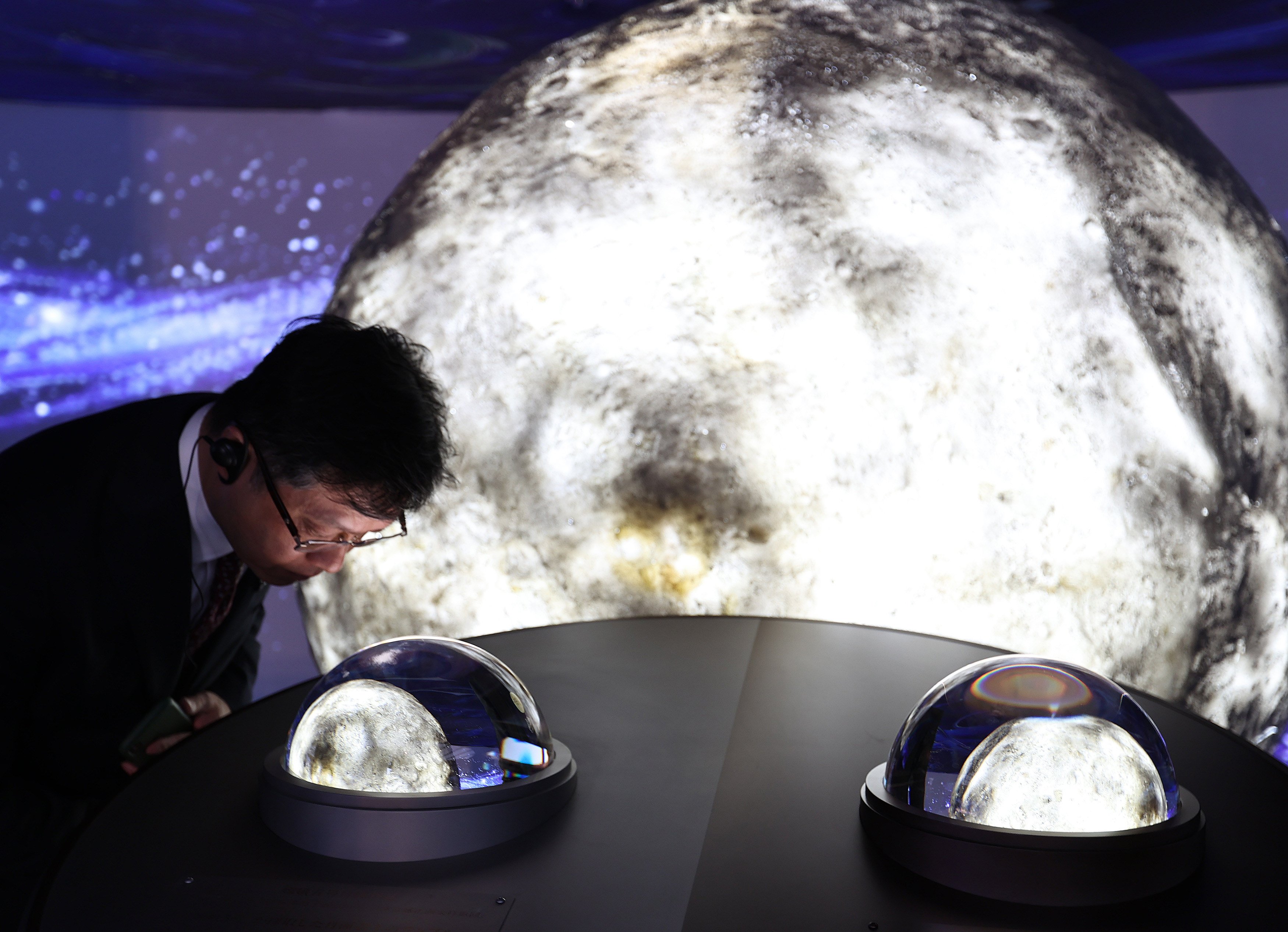 A visitor looks at lunar soil samples collected by China’s Chang’e-5 and Chang’e-6 missions at the Osaka Expo in Japan. Photo: Xinhua