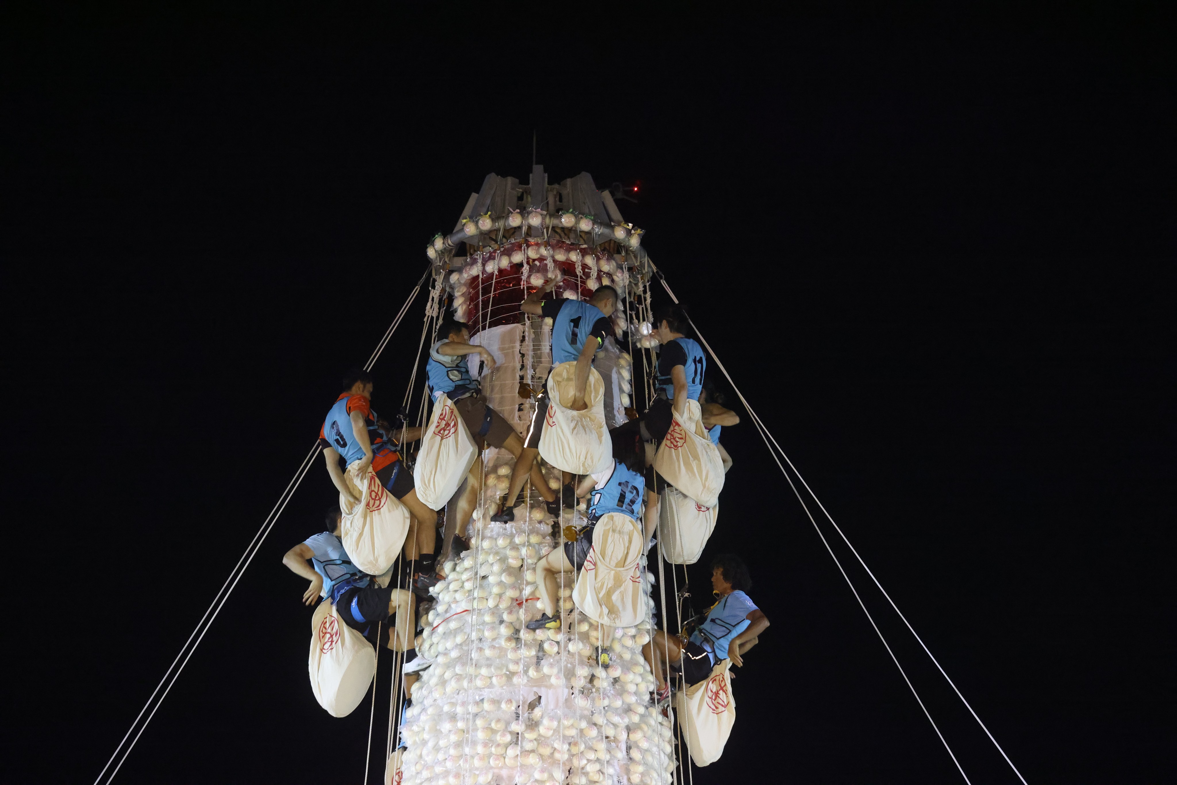 Competitors scramble up a bamboo bun tower to collect imitation Ping On buns during the annual Bun Festival in Cheung Chau. Photo: Yik Yeung-man