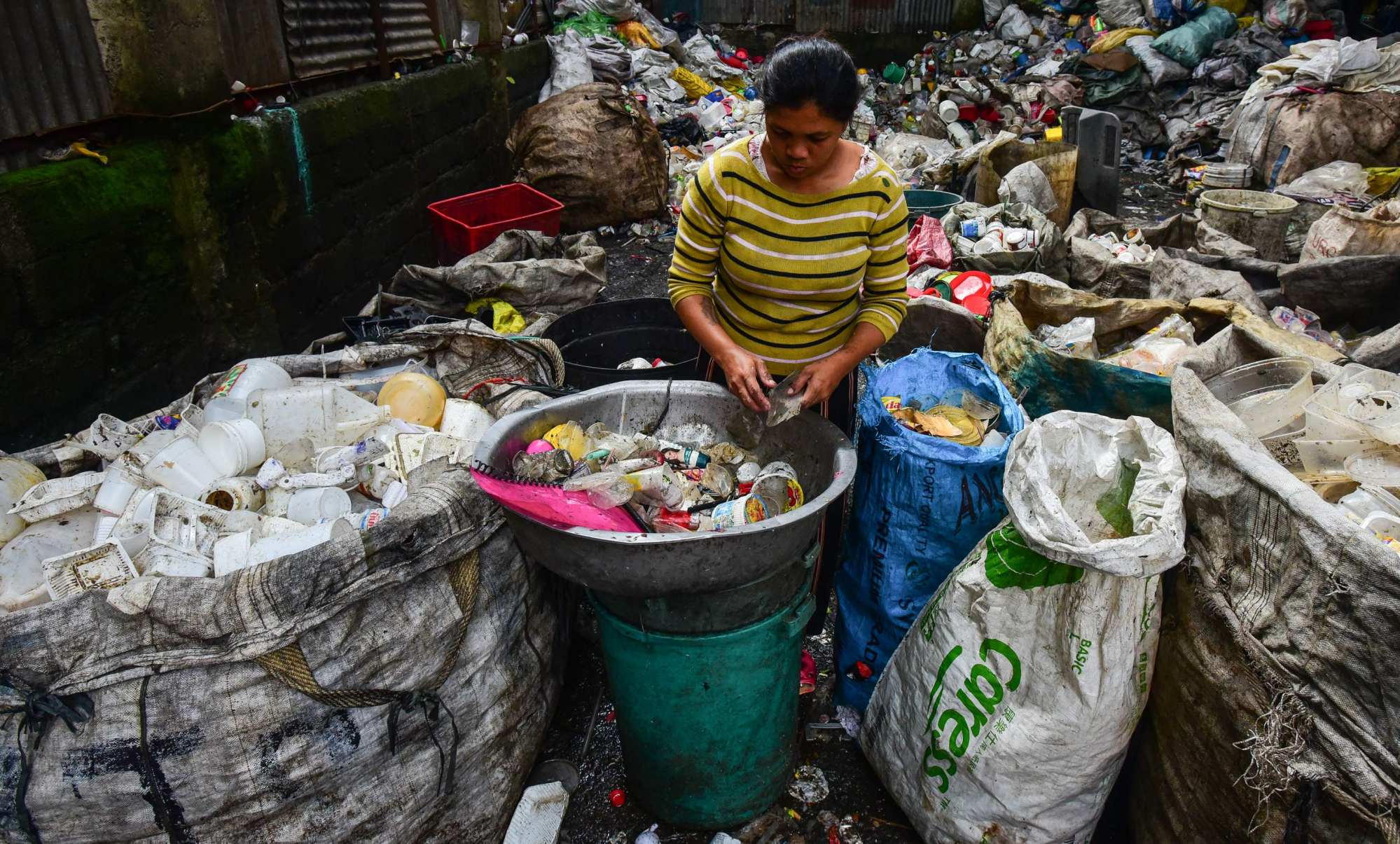 A woman sorts plastic items from piles of rubbish to be sold at recycling shops in Manila. Over 40 per cent of Filipinos living below the poverty line say they would vote for candidates who do not plan to assert the country’s maritime claims. Photo: AFP A woman sorts plastic items from piles of rubbish to be sold at recycling shops in Manila. Over 40 per cent of Filipinos living below the poverty line say they would vote for candidates who do not plan to assert the country’s maritime claims. Photo: AFP