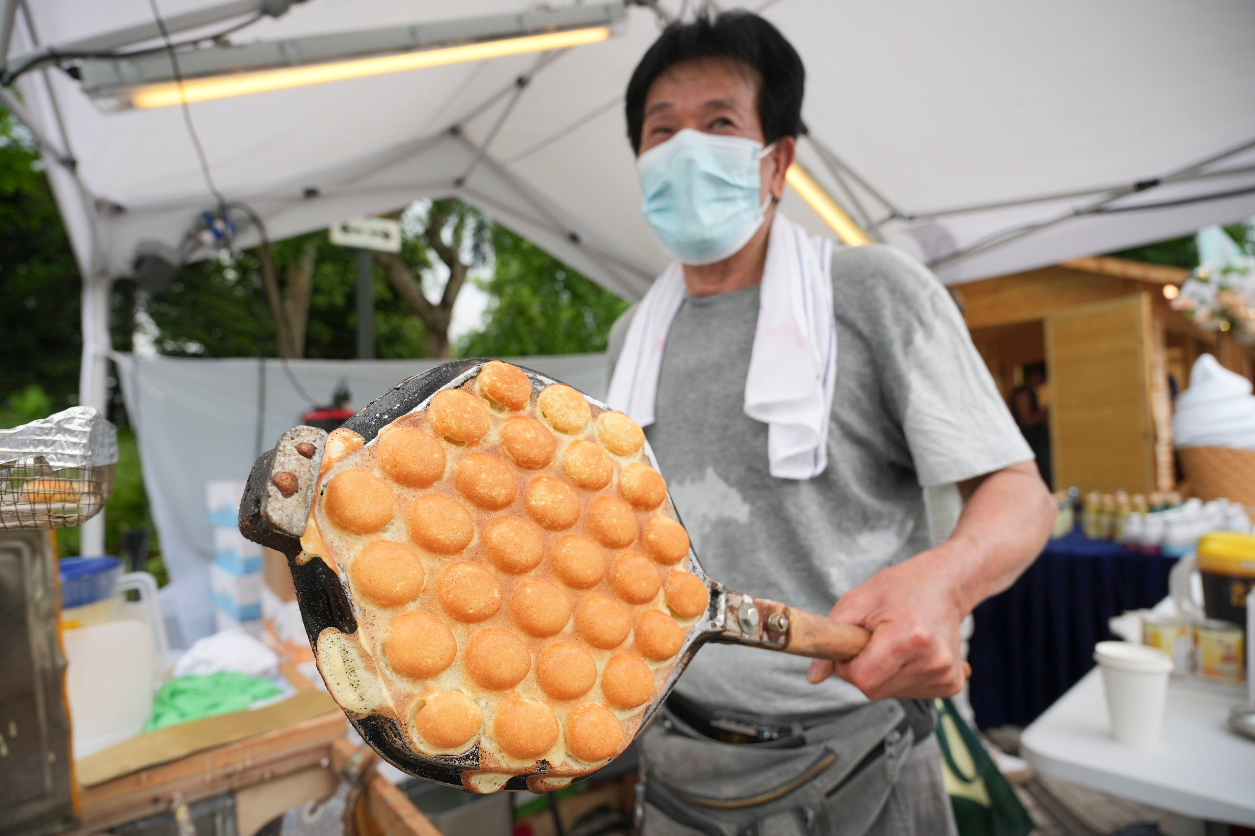 A foodseller known as “Uncle Lee” makes charcoal-grilled egg waffles at the “WestK Nightscape” event at West Kowloon Cultural District. Photo: May Tse