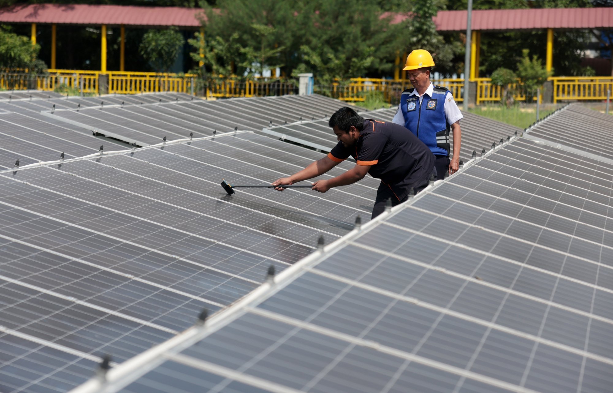 Workers clean solar panels in Depok, Indonesia. Photo: EPA-EFE Workers clean solar panels in Depok, Indonesia. Photo: EPA-EFE