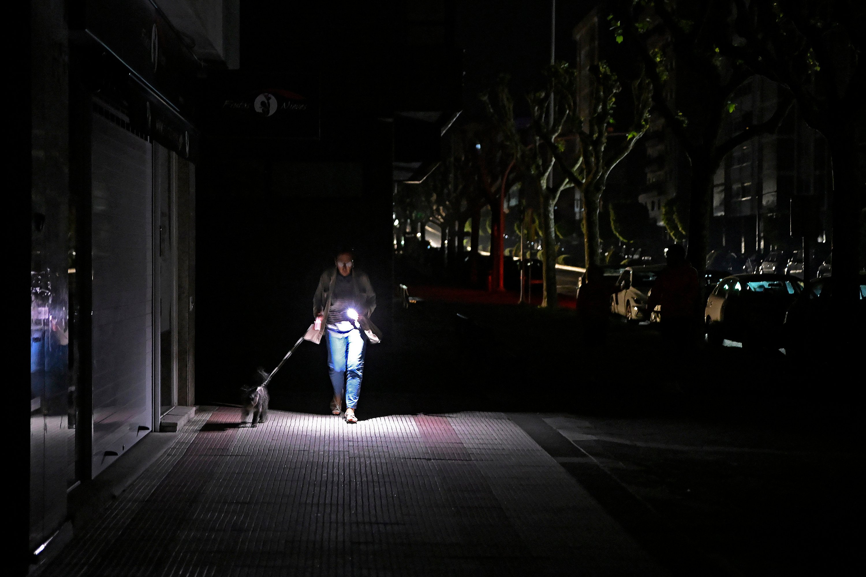 A woman walks her dog in Vigo, Spain. The country was among the European nations hit by a massive power cut on Monday. Photo: AFP/Getty Images/TNS