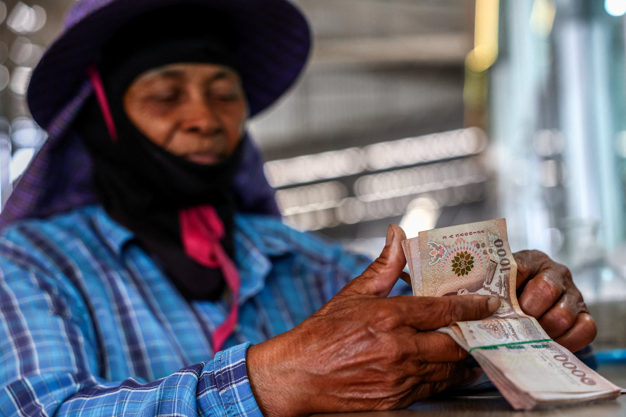 A Thai farmer counts the money she received from selling rice. Thai rice farmers face pressure from Washington’s new tariff regime. Photo: Reuters A Thai farmer counts the money she received from selling rice. Thai rice farmers face pressure from Washington’s new tariff regime. Photo: Reuters