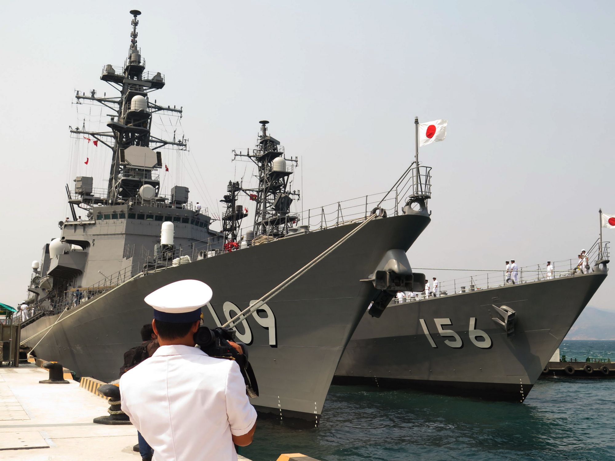 A Vietnamese navy officer films two Japanese destroyers anchored at Cam Ranh Bay in Vietnam. Photo: AFP A Vietnamese navy officer films two Japanese destroyers anchored at Cam Ranh Bay in Vietnam. Photo: AFP