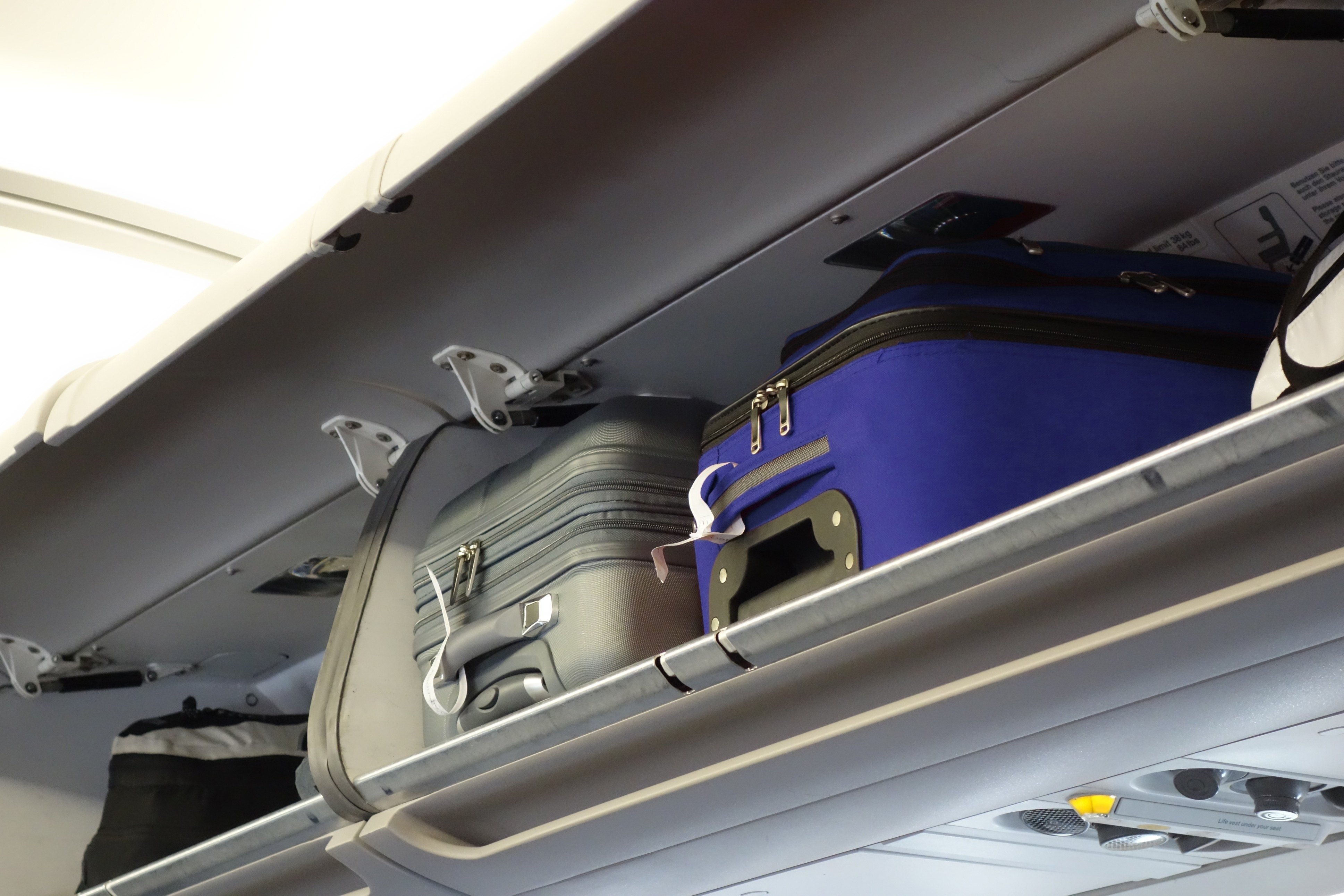 hand-luggage compartment with hand-luggage in an airplane Shutterstock