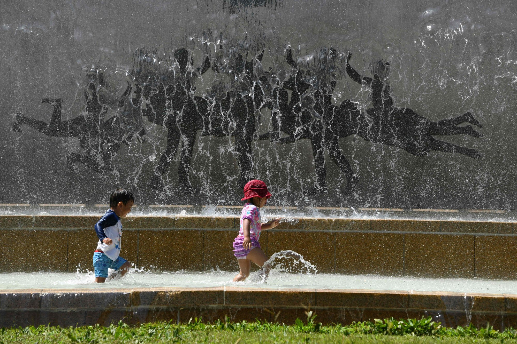 Children play in a water fountain in a Tokyo park, as a heatwave grips Japan in July 2018. Japan faces potential outdoor sports bans for children by 2060 due to soaring summer temperatures. Photo: AFP Children play in a water fountain in a Tokyo park, as a heatwave grips Japan in July 2018. Japan faces potential outdoor sports bans for children by 2060 due to soaring summer temperatures. Photo: AFP