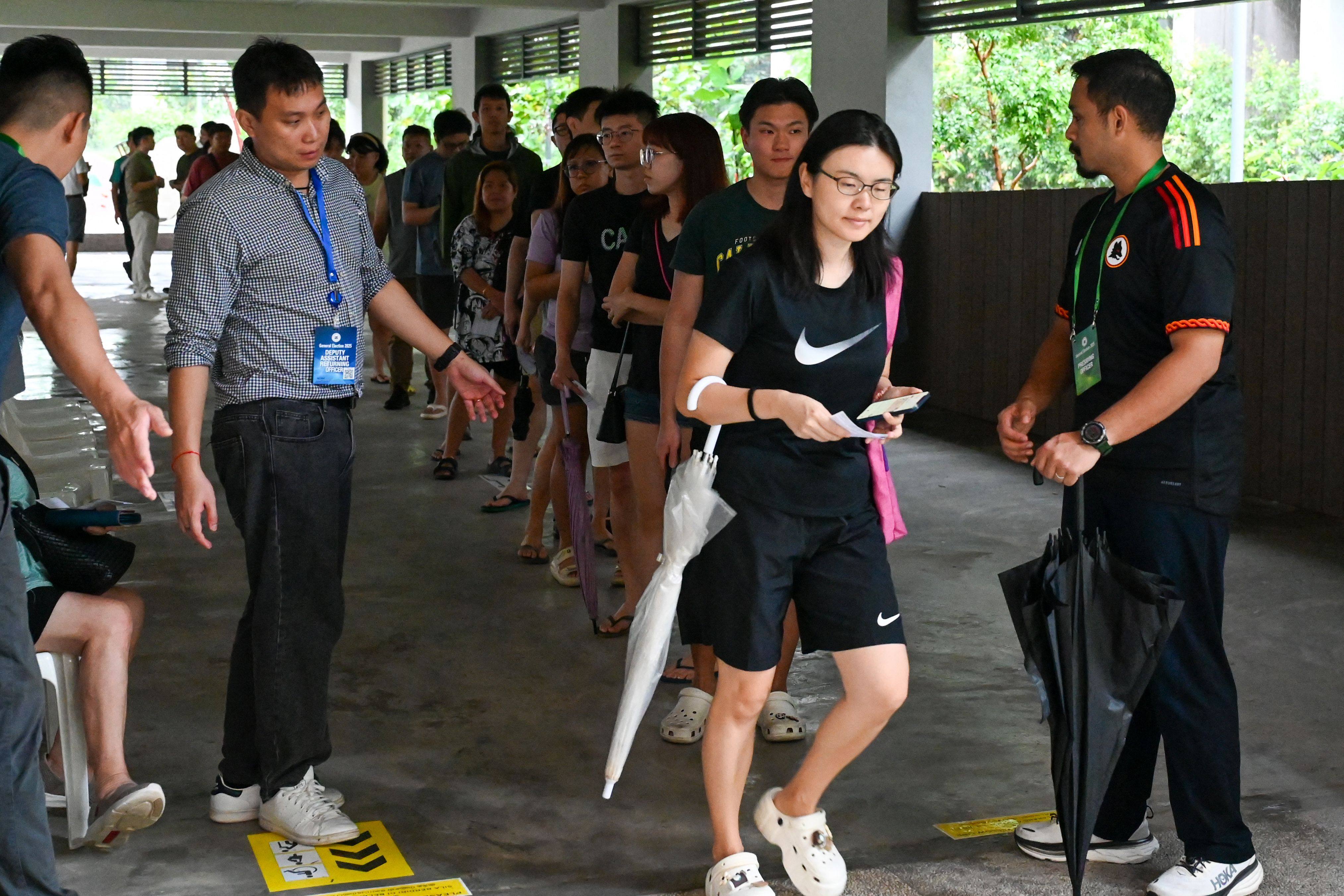 People queue to vote in Singapore’s general election at a polling station in the city state on Saturday. Photo: AFP