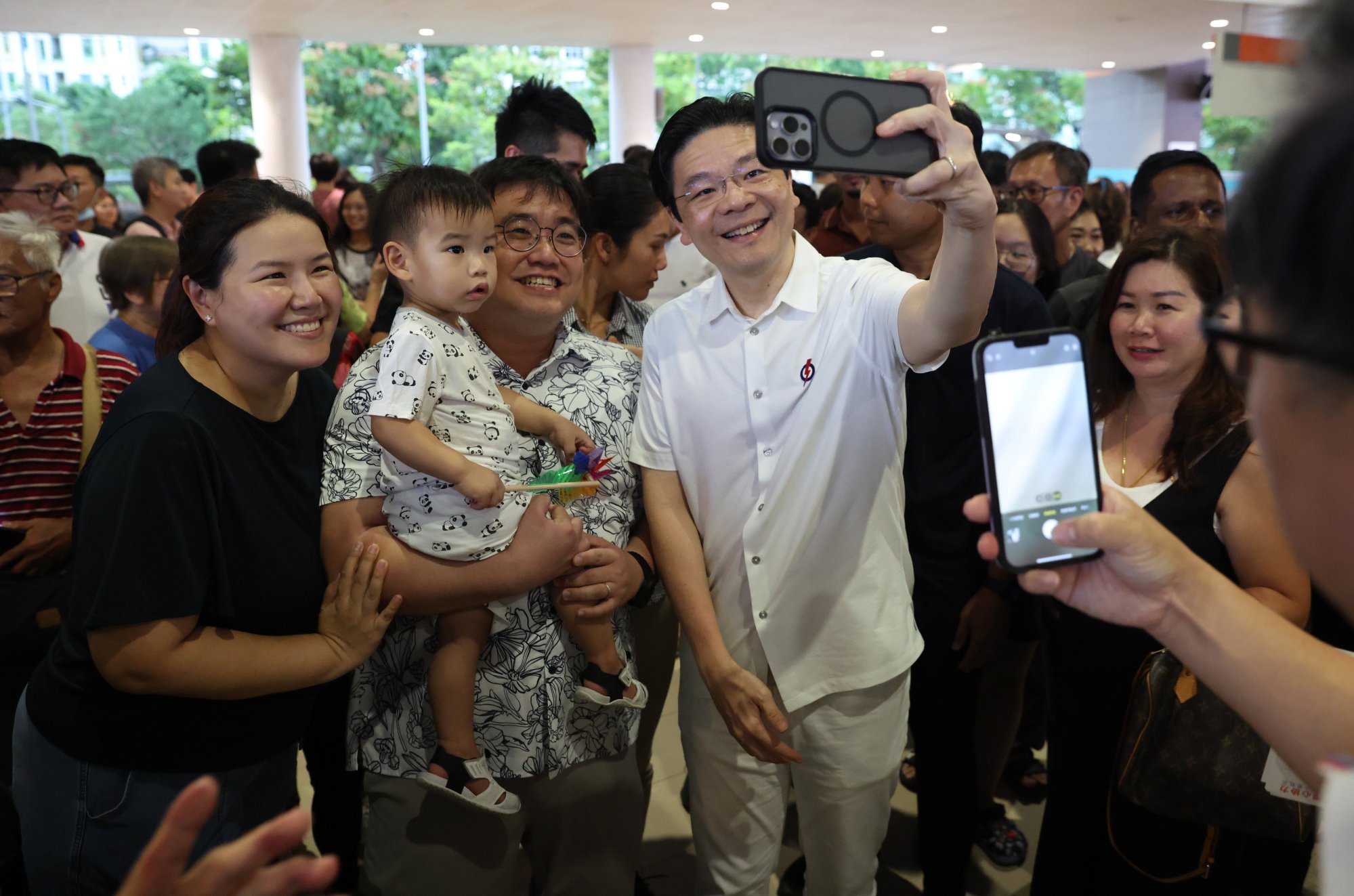 Singapore’s Prime Minister Lawrence Wong takes a selfie with residents during an election campaign walkabout session on Wednesday. Photo: EPA-EFE Singapore’s Prime Minister Lawrence Wong takes a selfie with residents during an election campaign walkabout session on Wednesday. Photo: EPA-EFE