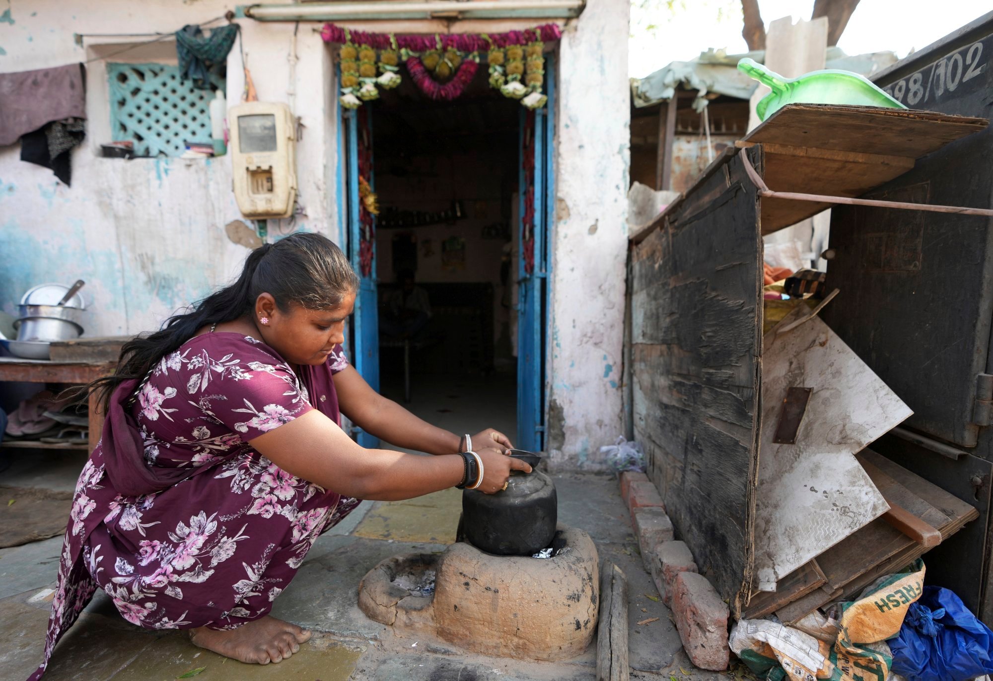 Puja Vanzara, wearing a wristwatch-style health monitor to study how heat affects vulnerable communities, works at her house in Vanzara Vas, India, on April 2. Photo: AP Puja Vanzara, wearing a wristwatch-style health monitor to study how heat affects vulnerable communities, works at her house in Vanzara Vas, India, on April 2. Photo: AP