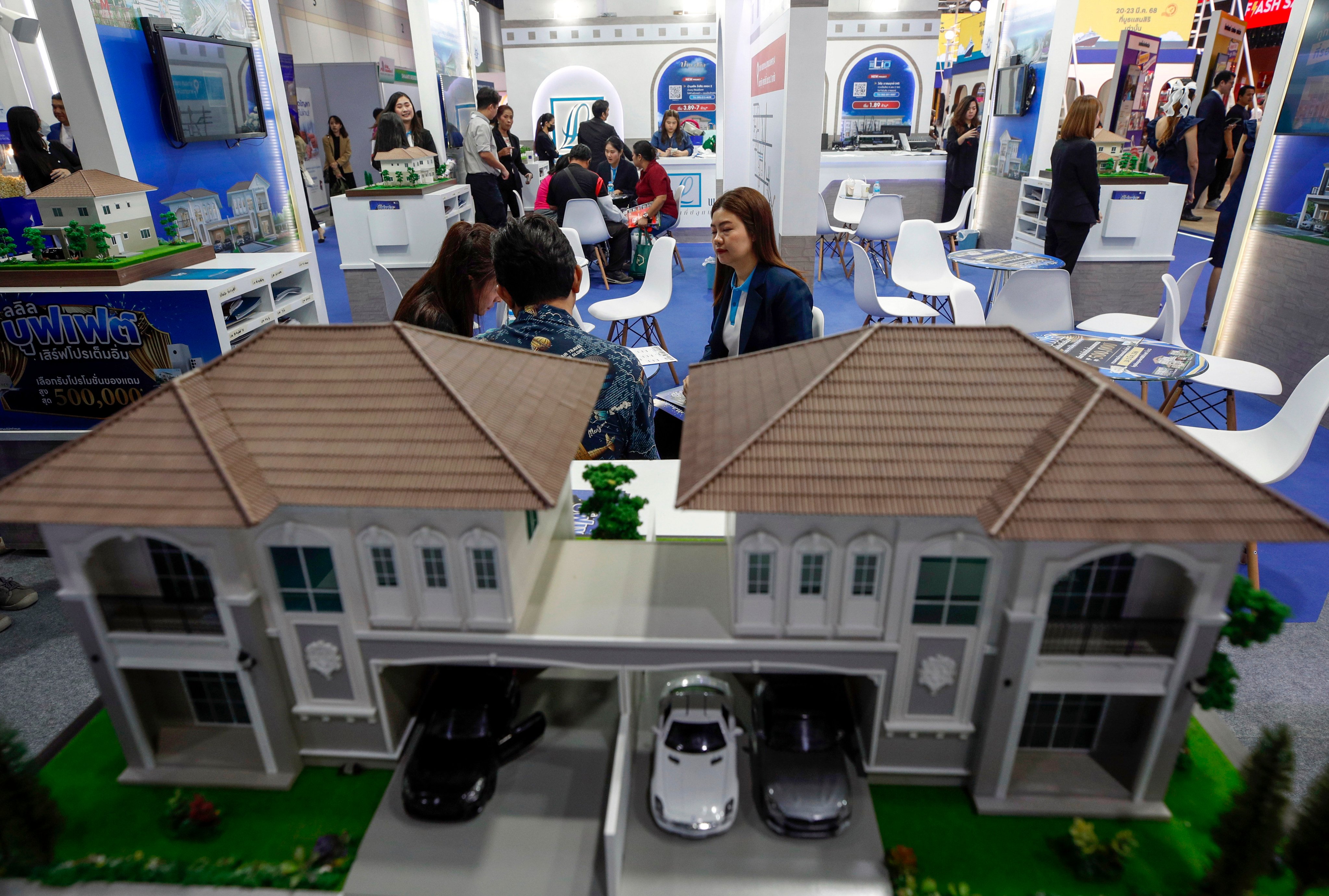 Potential homebuyers evaluate residential promotions from a salesperson at the 47th House and Condo Expo in Bangkok, Thailand, on March 20, 2025. Photo: EPA-EFE