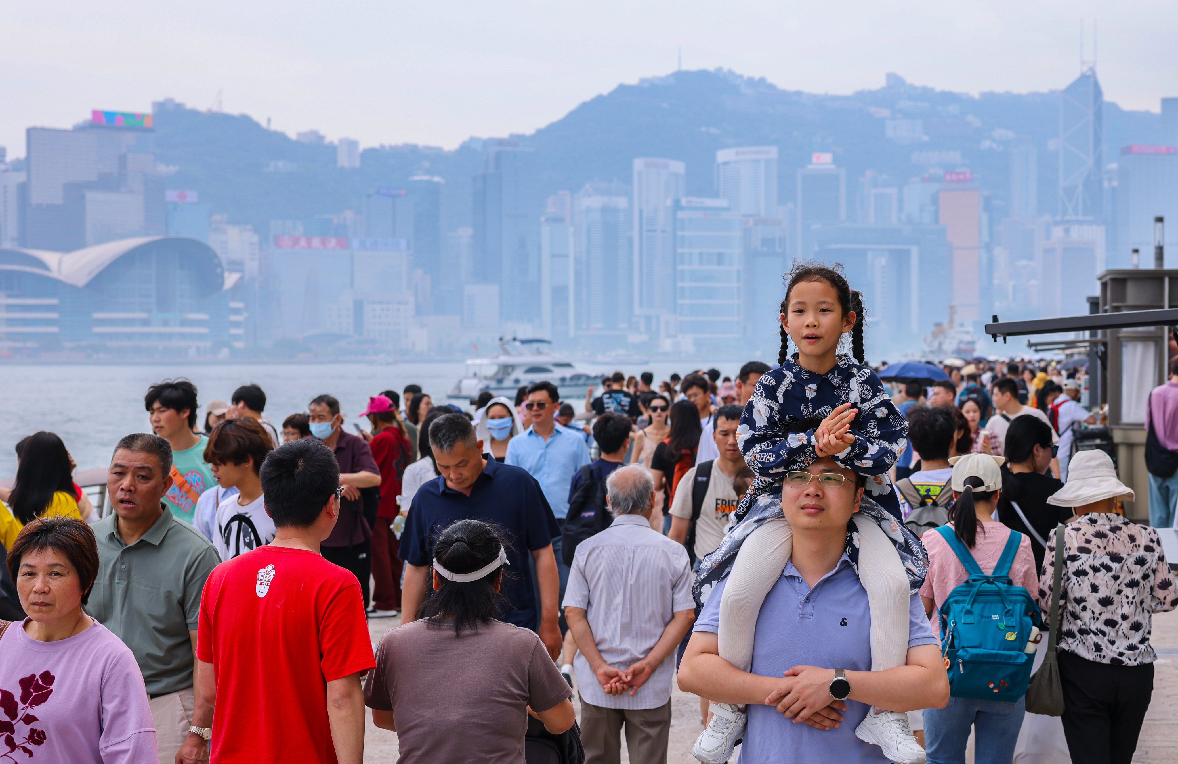 Mainland tourists enjoy a walk at the harbourfront in Tsim Sha Tsui on the third day of the Labour Day “golden week” holiday. Photo: Nora Tam