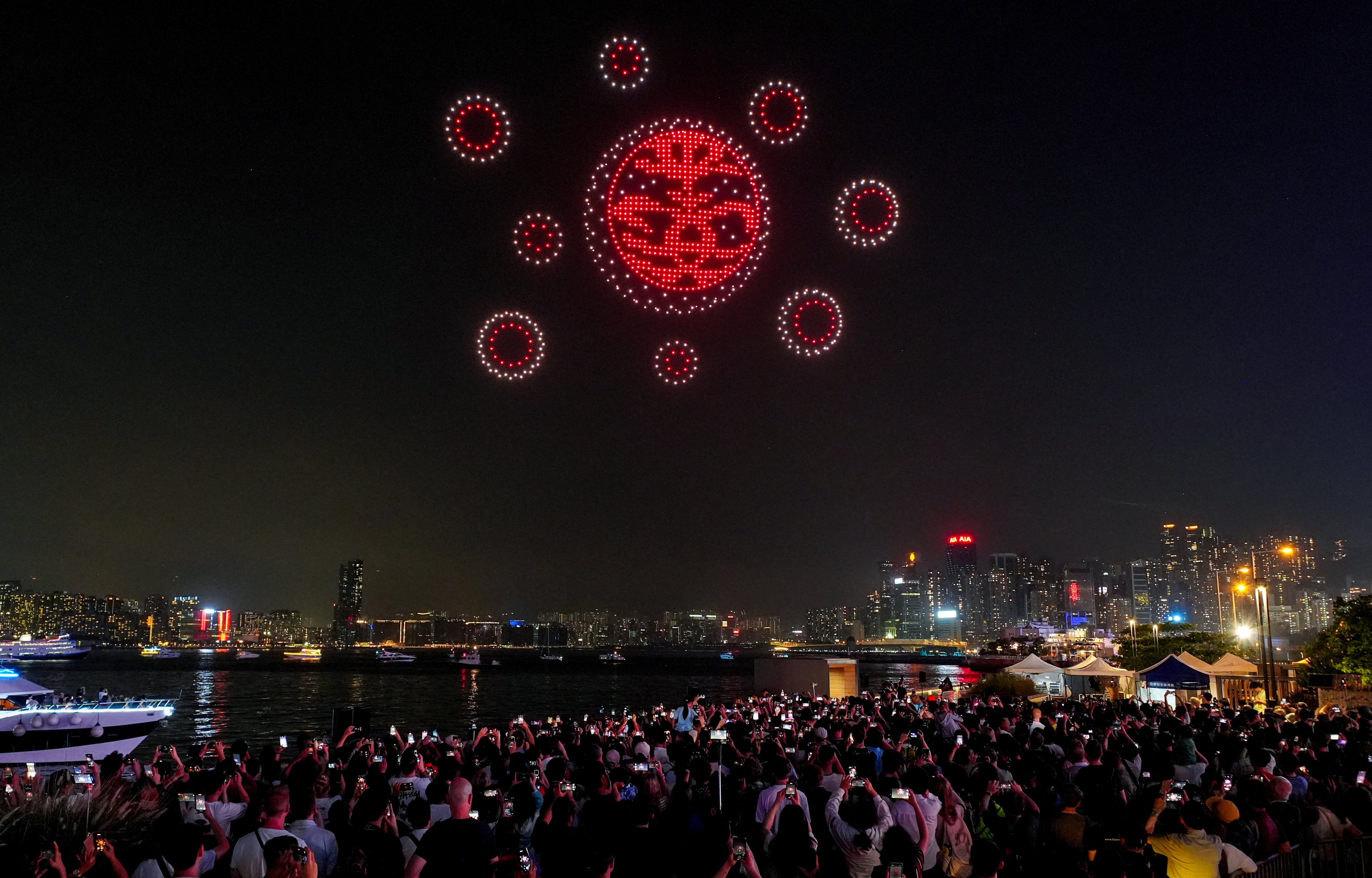 People gather at the Wan Chai promenade to watch a drone show on the Labour Day public holiday. Photo: Elson Li