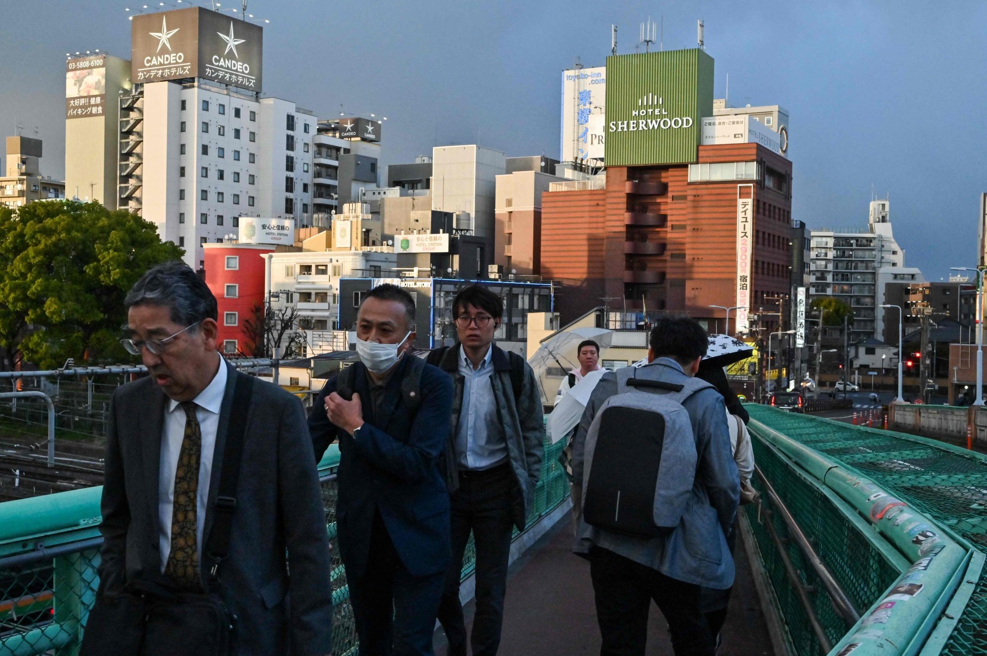 People walk across a bridge spanning railway tracks in Tokyo. A recent survey showed 62 per cent of Japanese people feared the nation would be caught up in a conflict in the coming years. Photo: AFP People walk across a bridge spanning railway tracks in Tokyo. A recent survey showed 62 per cent of Japanese people feared the nation would be caught up in a conflict in the coming years. Photo: AFP
