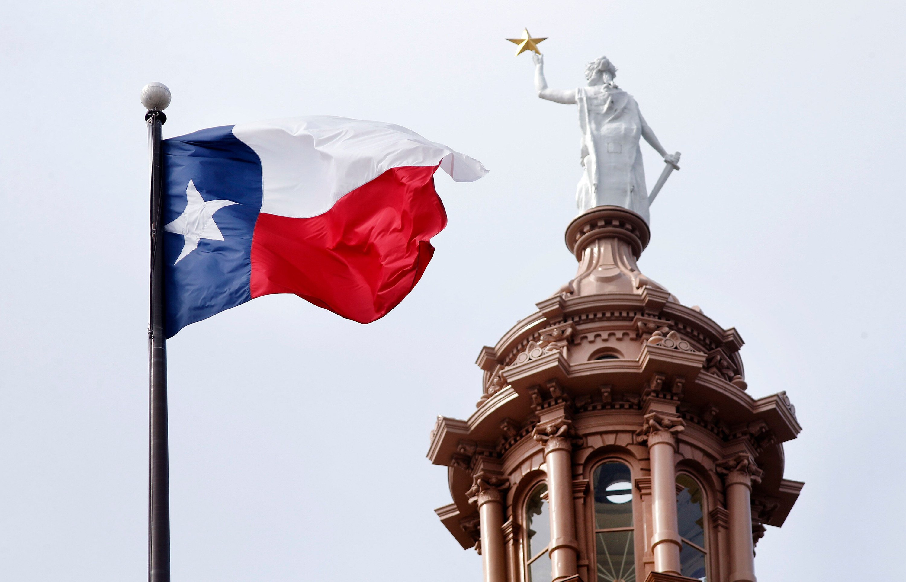 The Texas flag flies over the Texas Capitol in Austin. Photo: TNS