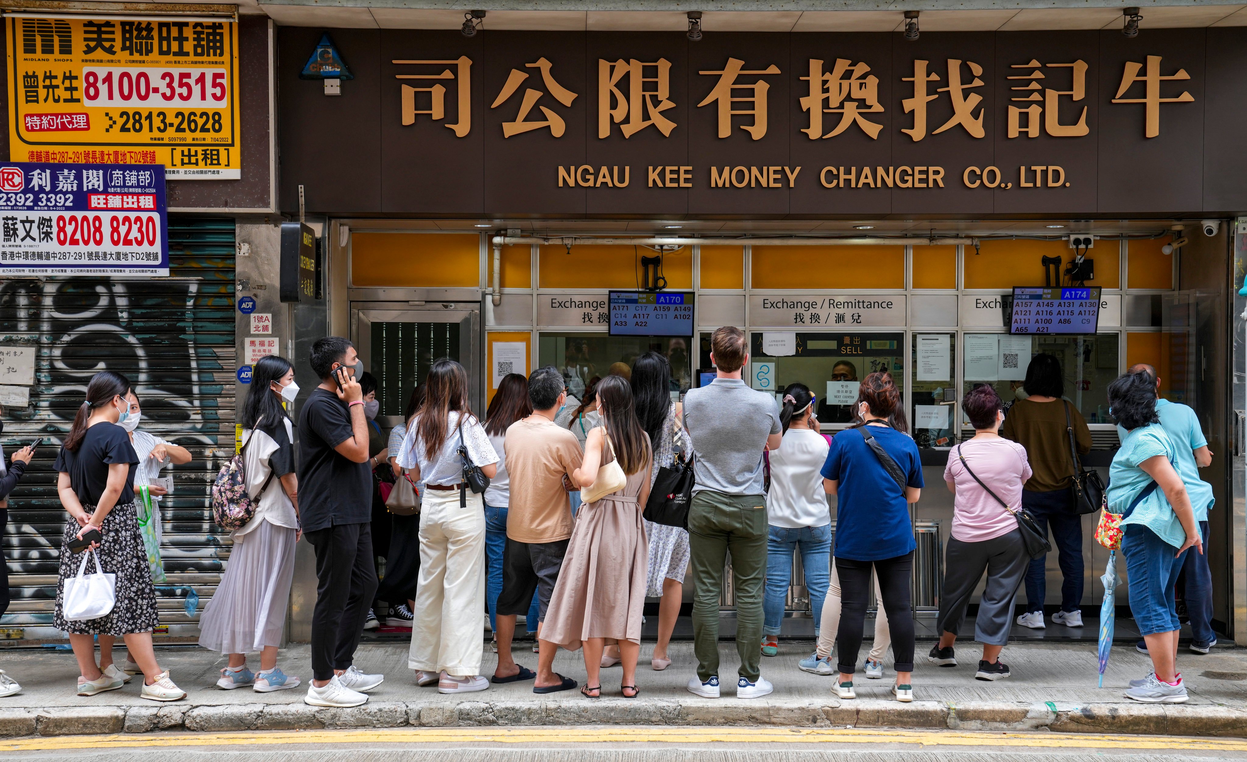 People queue outside a money changer in Sheung Wan. Photo: Sam Tsang
