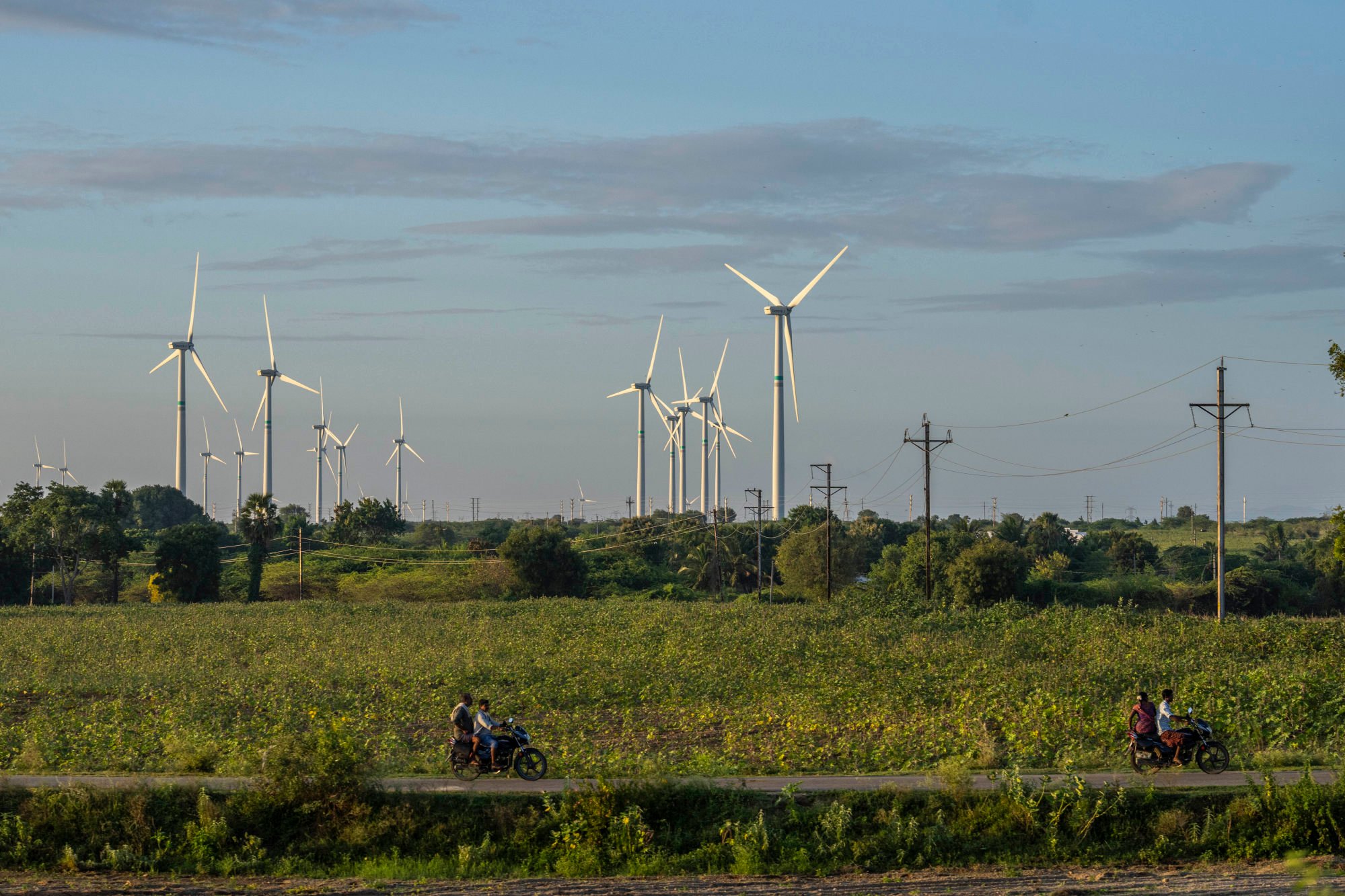 People ride their motorcycles past a windmill farm in Anantapur district, Andhra Pradesh. India became the world’s third-largest producer of electricity from wind and solar energy in 2024. Photo: AP People ride their motorcycles past a windmill farm in Anantapur district, Andhra Pradesh. India became the world’s third-largest producer of electricity from wind and solar energy in 2024. Photo: AP