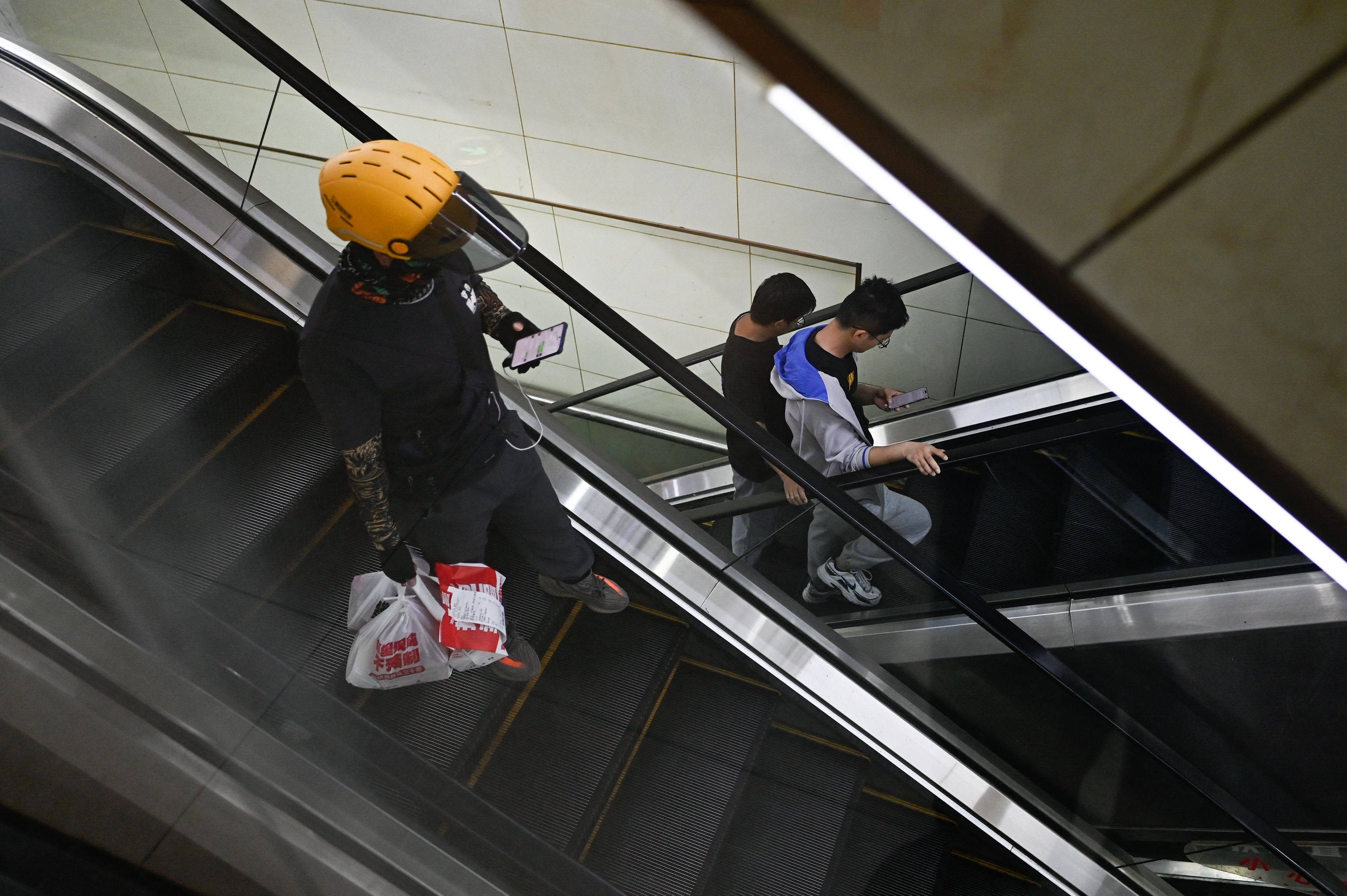 A delivery man carries packages of food during lunchtime in Beijing on April 28. Photo: AFP