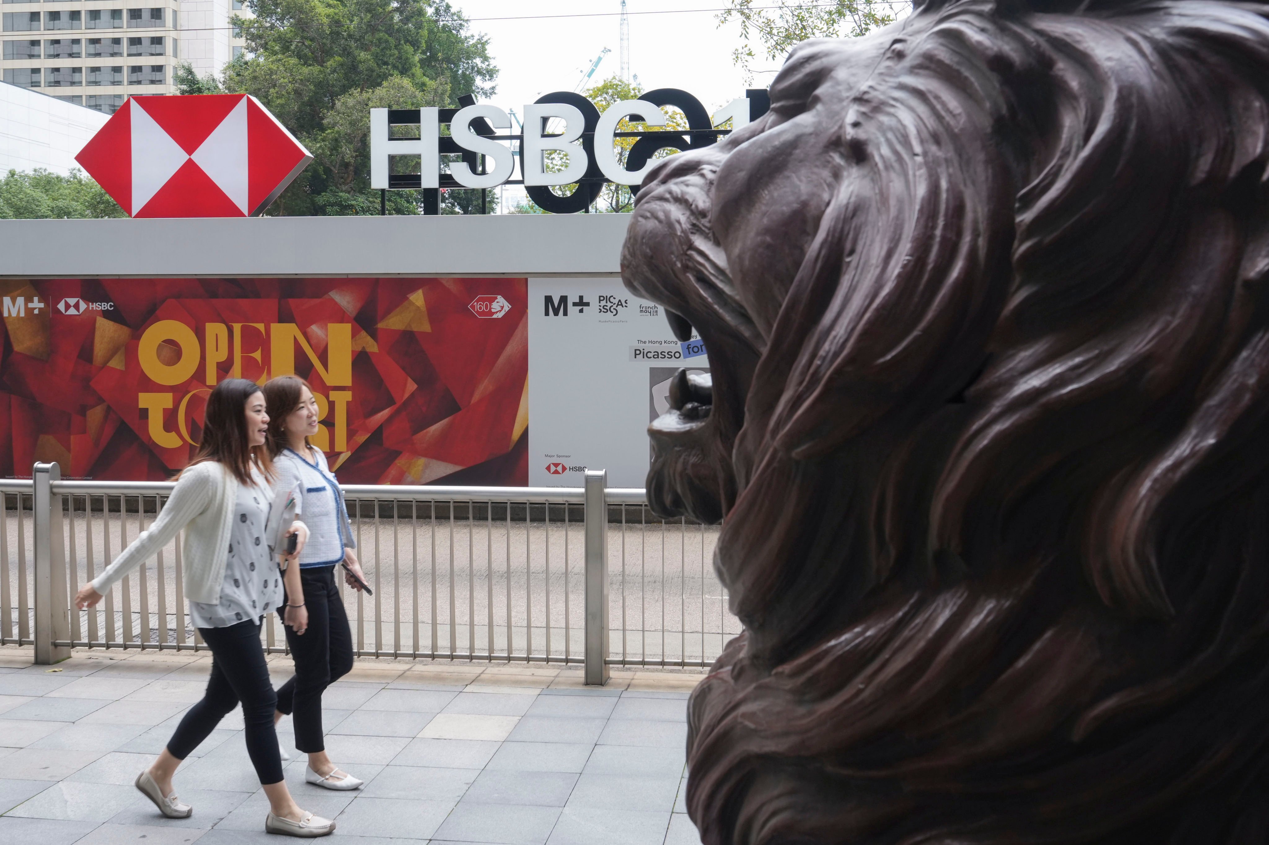 People walking past a lion sculpture outside HSBC’s main office building in Central. Photo: Sun Yeung