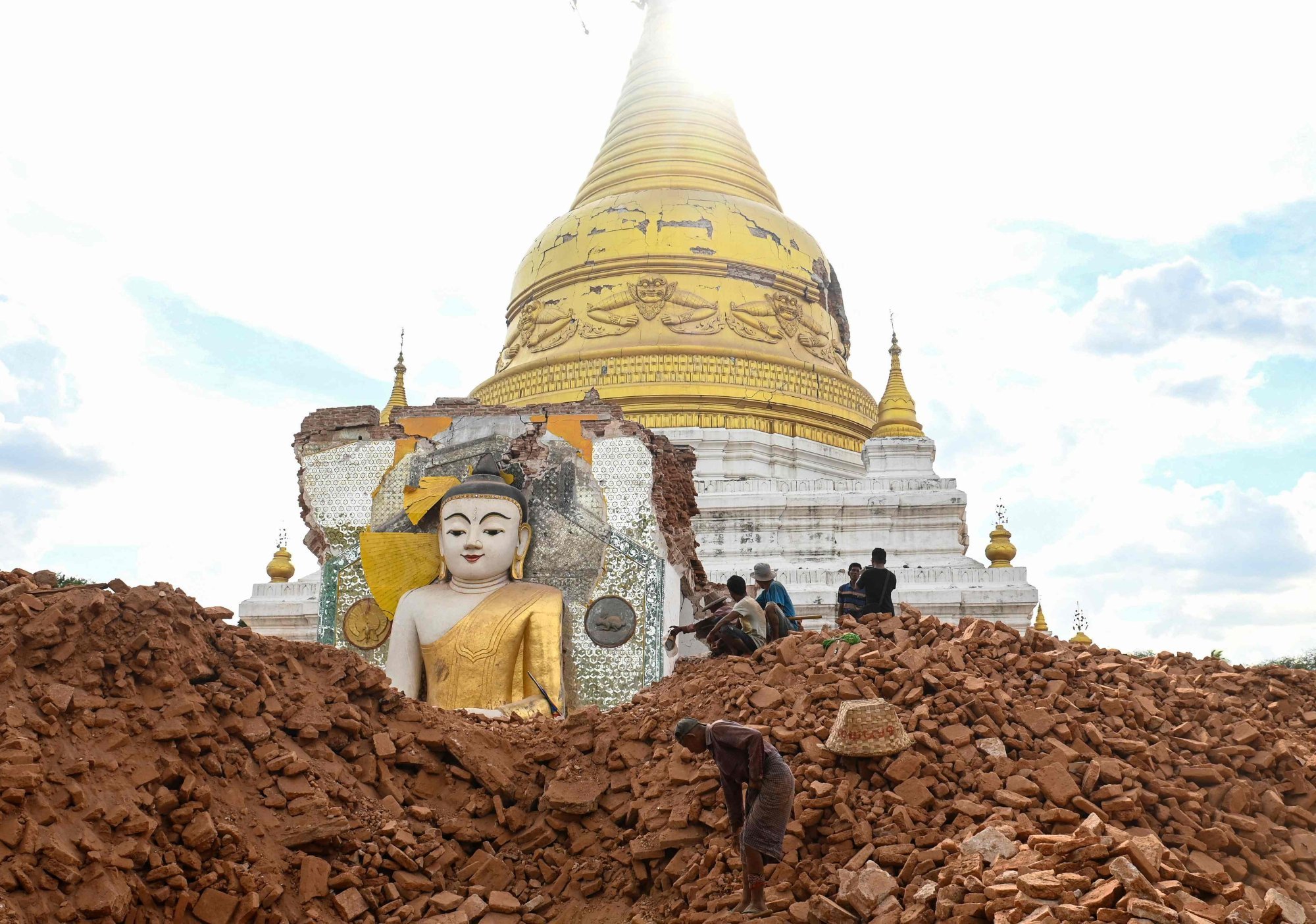 A man clears debris around a damaged Buddha statue at Lawkatharaphu Pagoda in Inwa on the outskirts of Mandalay, following the devastating March 28 earthquake. Photo: AFP A man clears debris around a damaged Buddha statue at Lawkatharaphu Pagoda in Inwa on the outskirts of Mandalay, following the devastating March 28 earthquake. Photo: AFP