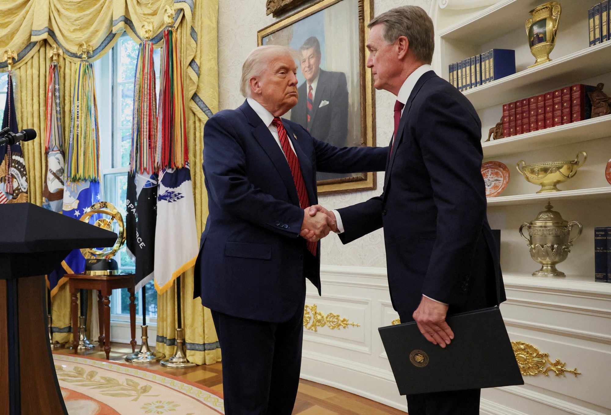 Trump shakes hands with former US senator David Perdue during his swearing-in ceremony to be America’s new ambassador to China at the Oval Office of the White House in Washington on Wednesday. Photo: Reuters Trump shakes hands with former US senator David Perdue during his swearing-in ceremony to be America’s new ambassador to China at the Oval Office of the White House in Washington on Wednesday. Photo: Reuters