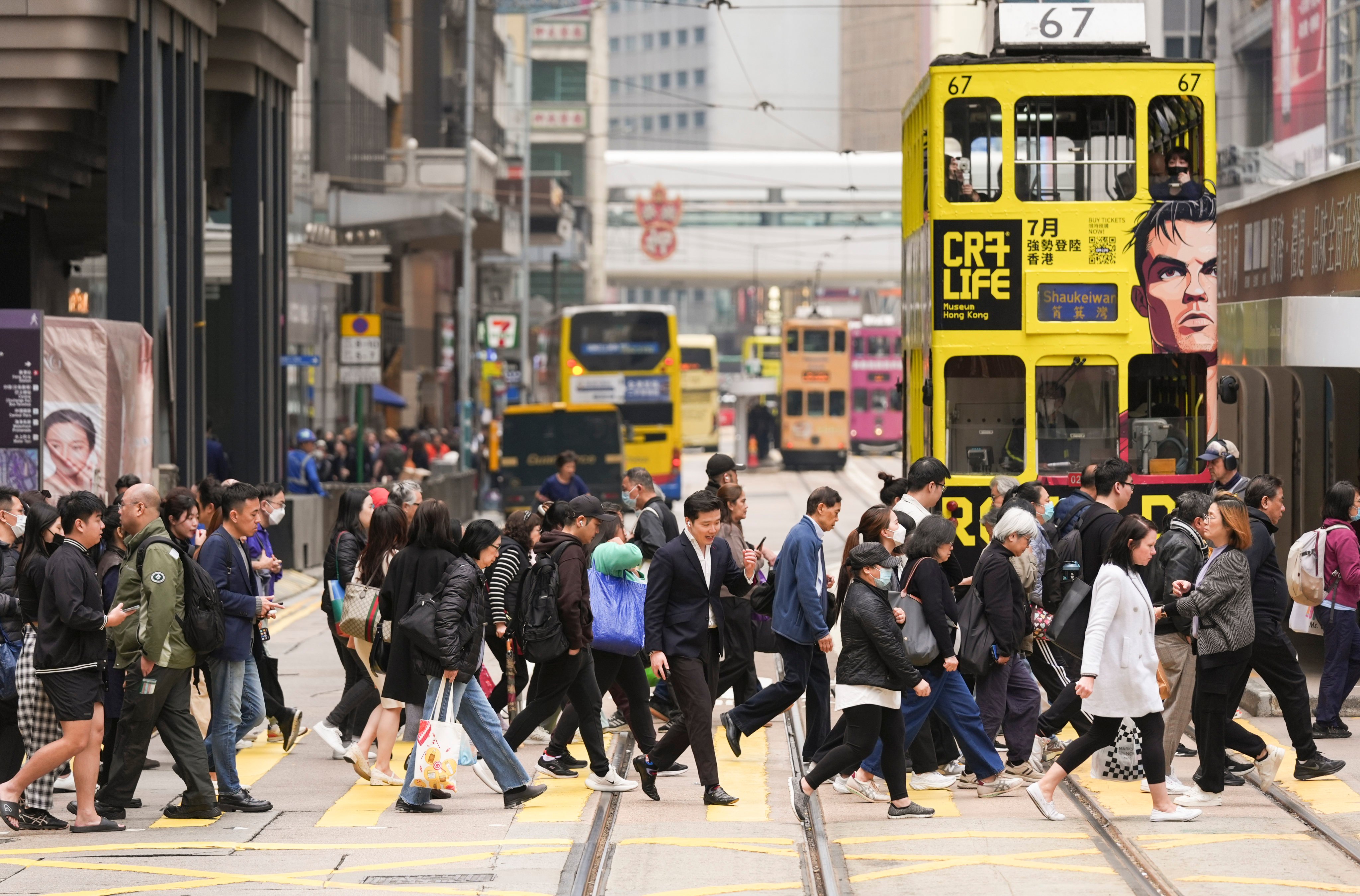Pedestrians cross the road in Hong Kong’s Central district on February 26. Photo: Eugene Lee