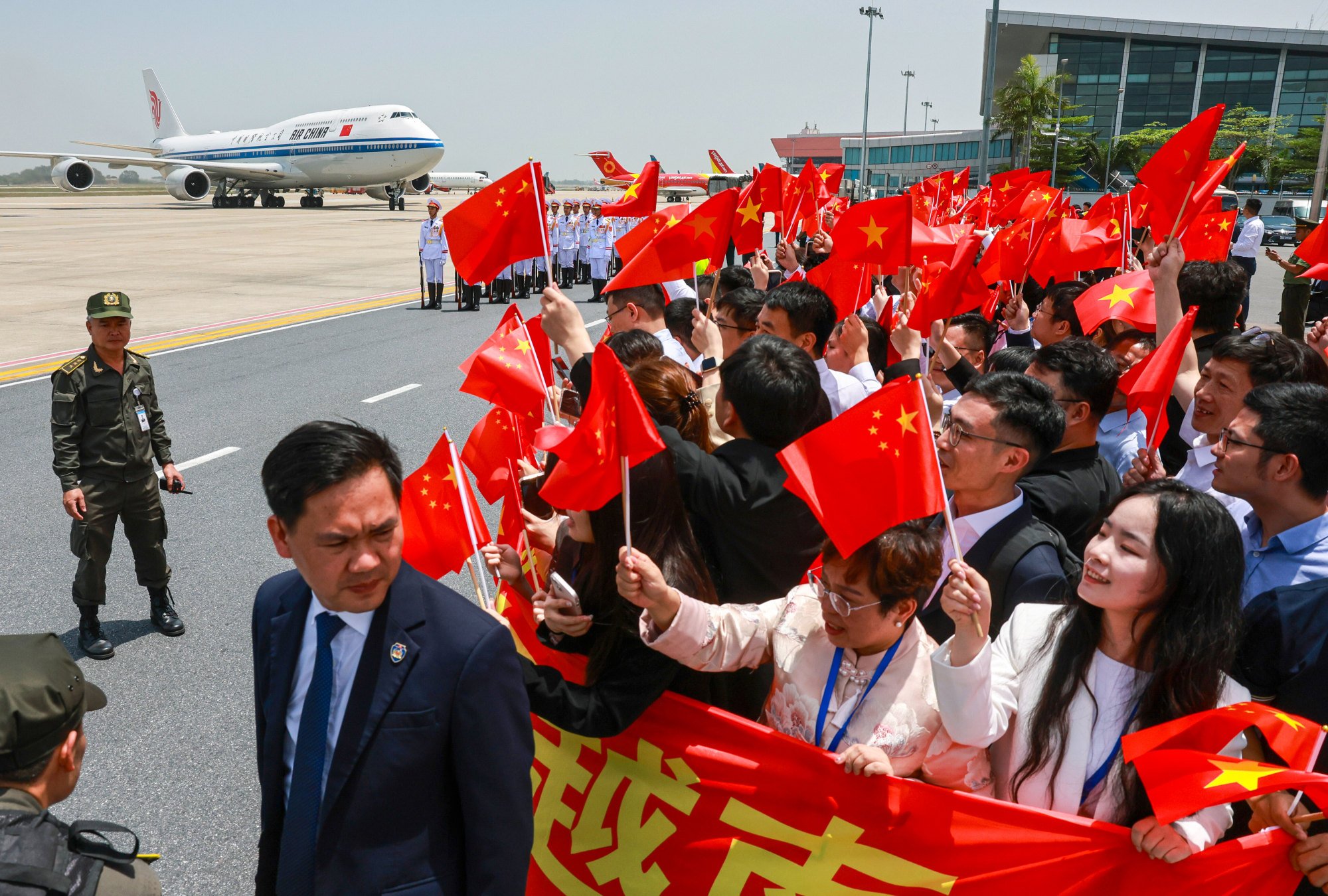 People wave Chinese flags as the plane carrying Chinese President Xi Jinping arrives at the Noi Bai International Airport in Hanoi, Vietnam, on April 14. Photo: AP People wave Chinese flags as the plane carrying Chinese President Xi Jinping arrives at the Noi Bai International Airport in Hanoi, Vietnam, on April 14. Photo: AP