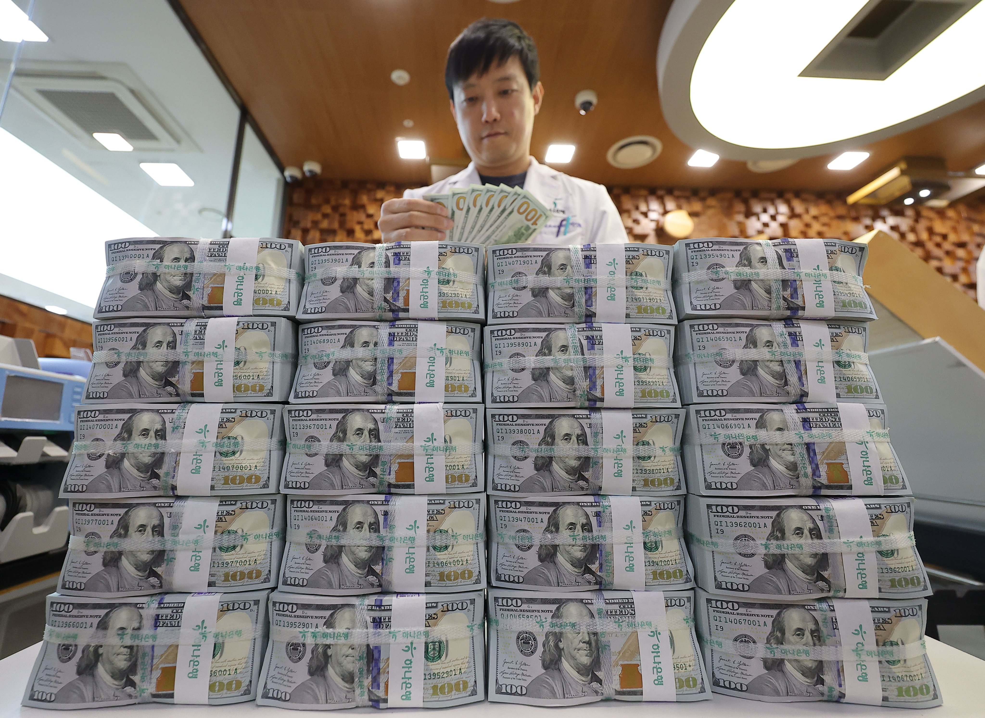 A clerk sorts US dollar banknotes at a bank in Seoul, South Korea, on April 15. Photo: EPA-EFE