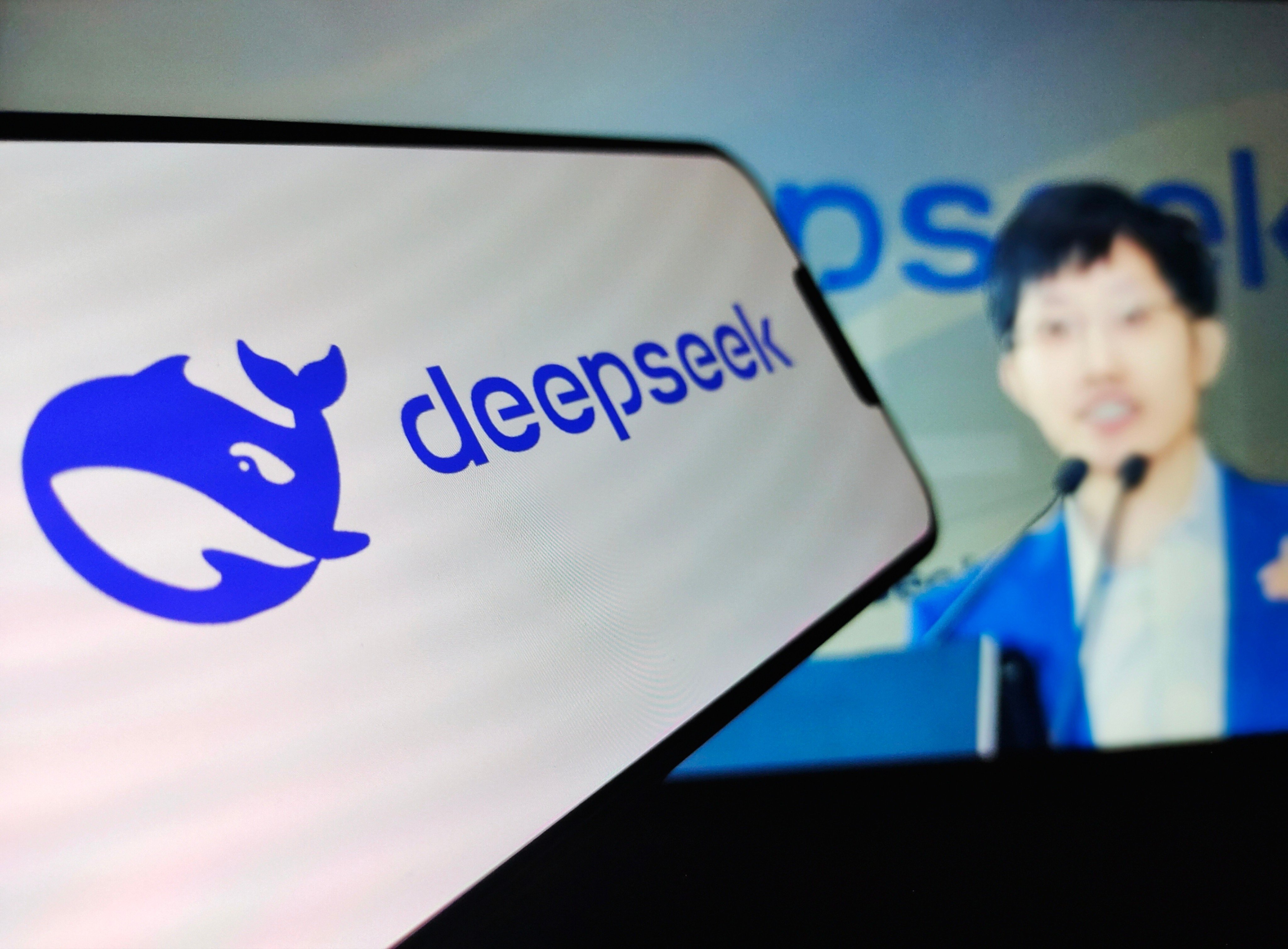 DeepSeek founder Liang Wenfeng, in the background, follows an open-source approach in AI development. Photo: Shutterstock
