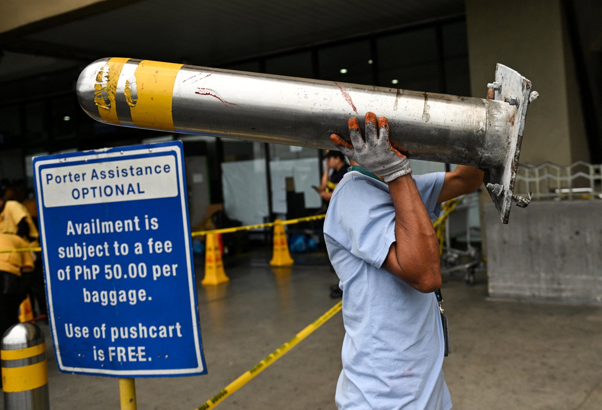 A worker carries a bloodied metal bollard at Ninoy Aquino International Airport Terminal 1 after a deadly crash on May 4. Photo: Reuters A worker carries a bloodied metal bollard at Ninoy Aquino International Airport Terminal 1 after a deadly crash on May 4. Photo: Reuters