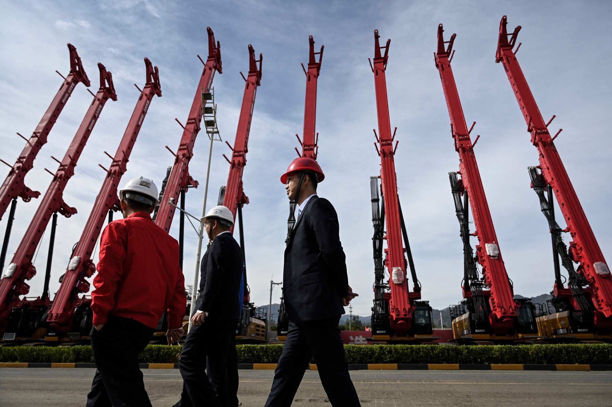 People walk past cranes made by Sany at a factory in Beijing in October 2021. Photo: AFP People walk past cranes made by Sany at a factory in Beijing in October 2021. Photo: AFP