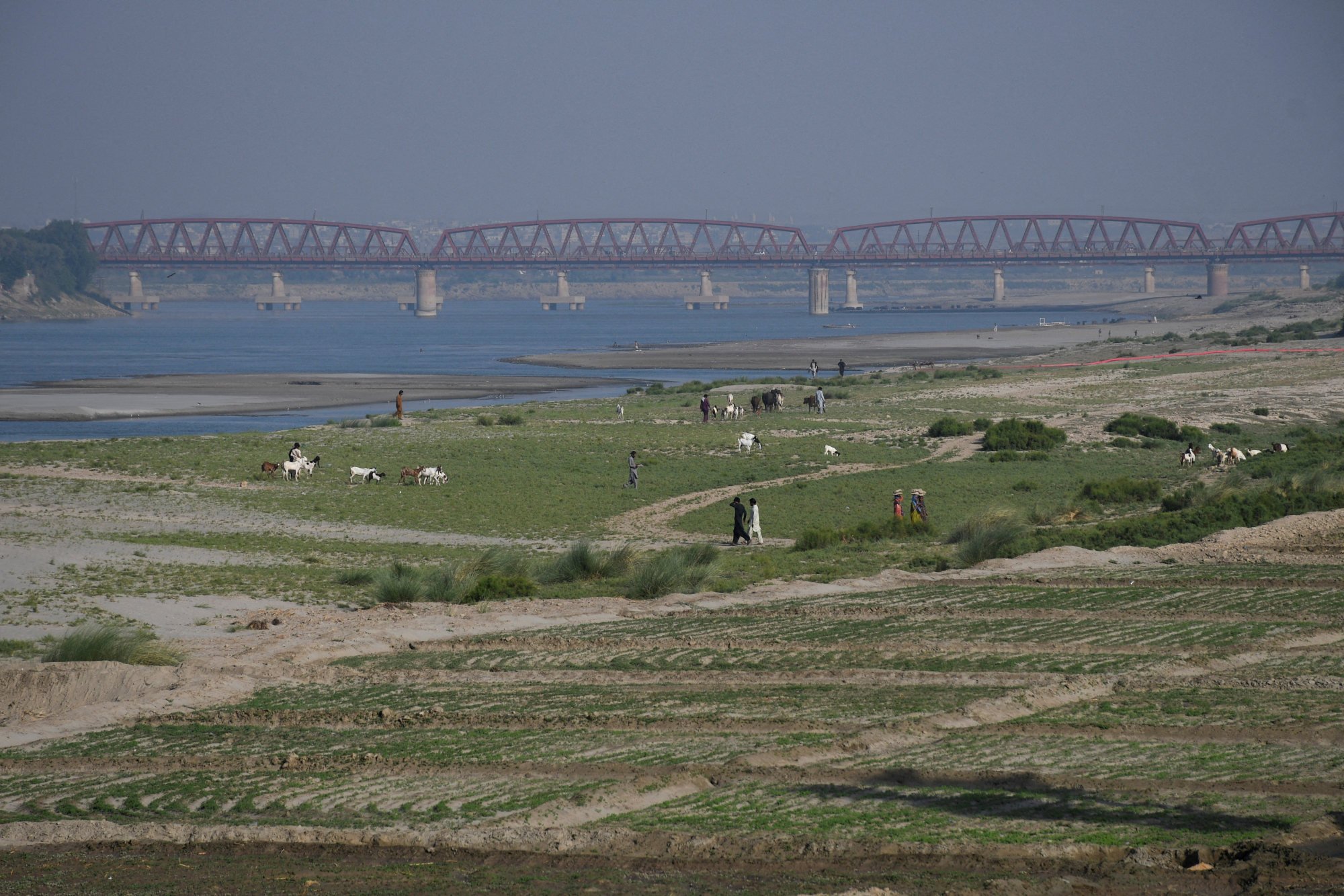 People walk next to cultivated land on the dry riverbed of the Indus River in Pakistan’s Sindh province last month. Photo: Reuters People walk next to cultivated land on the dry riverbed of the Indus River in Pakistan’s Sindh province last month. Photo: Reuters